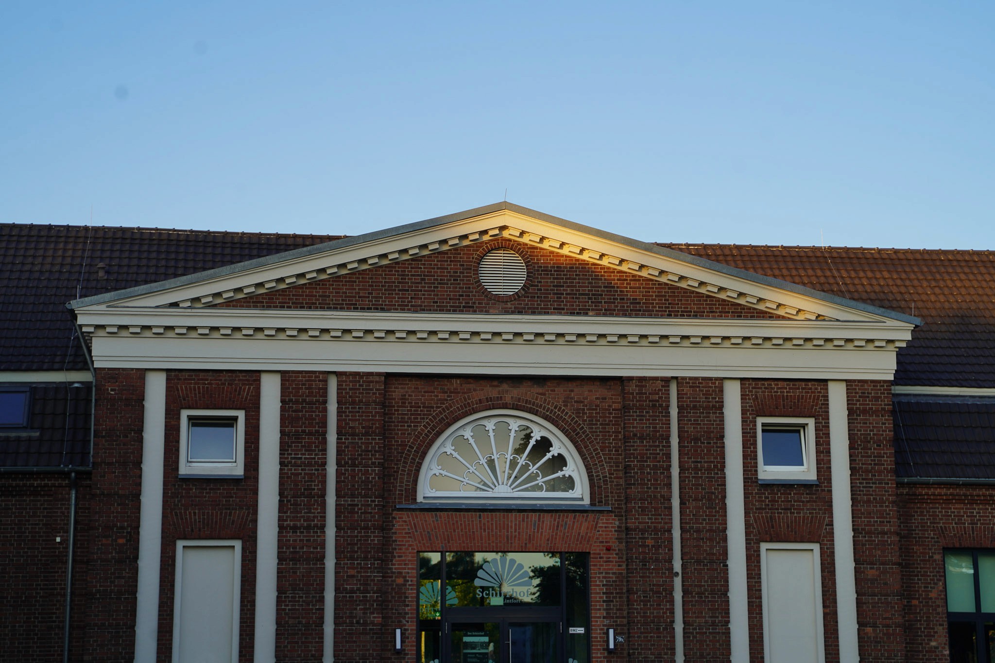 Historisches Backsteingebäude auf dem Schirrhofgelände mit charakteristischem Fenster, im sommerlichen Sonnenlicht fotografiert.