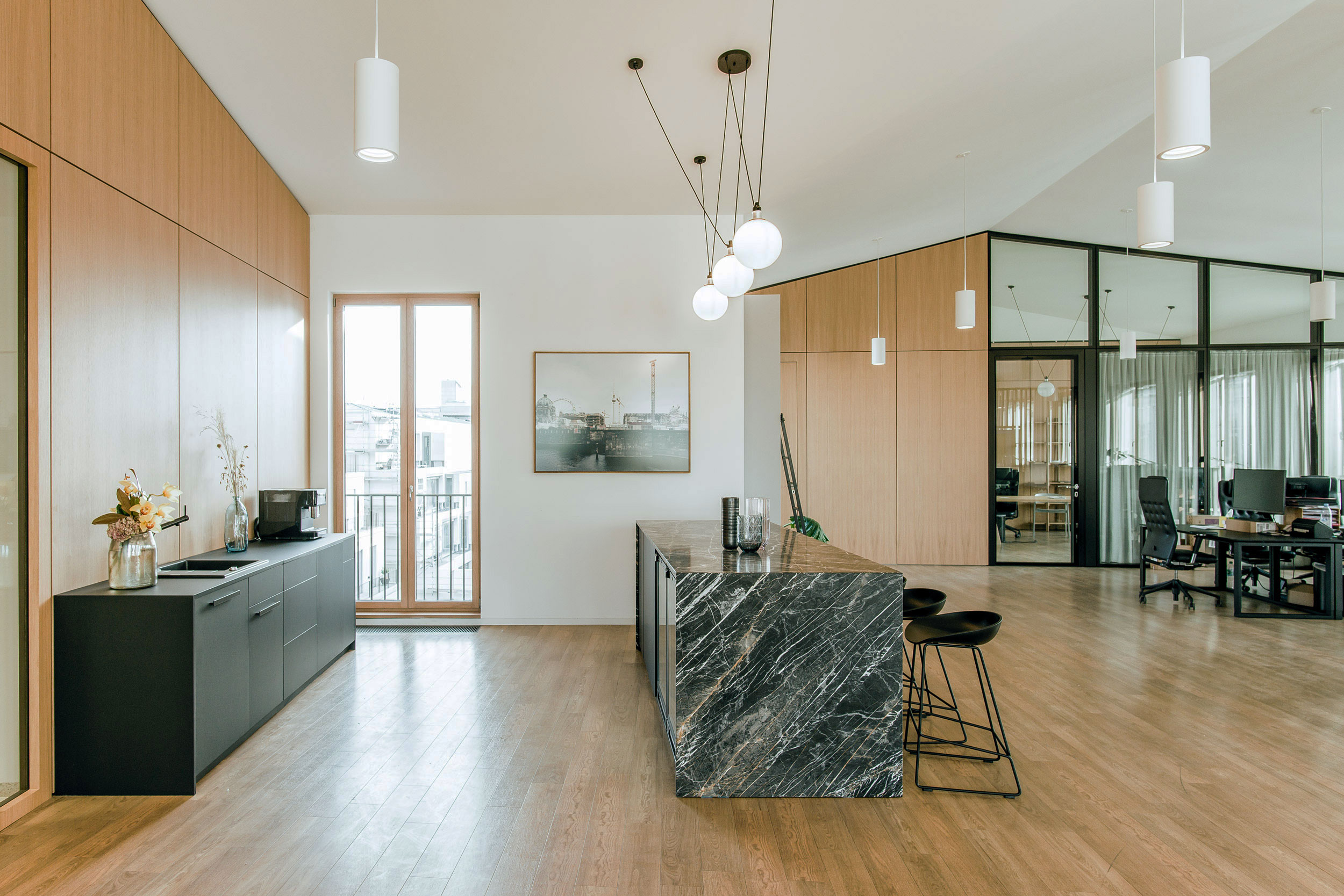 Offene Büroküche im modernen Office in Berlin-Mitte mit integrierter Bar und fließendem Übergang zur Arbeitslandschaft