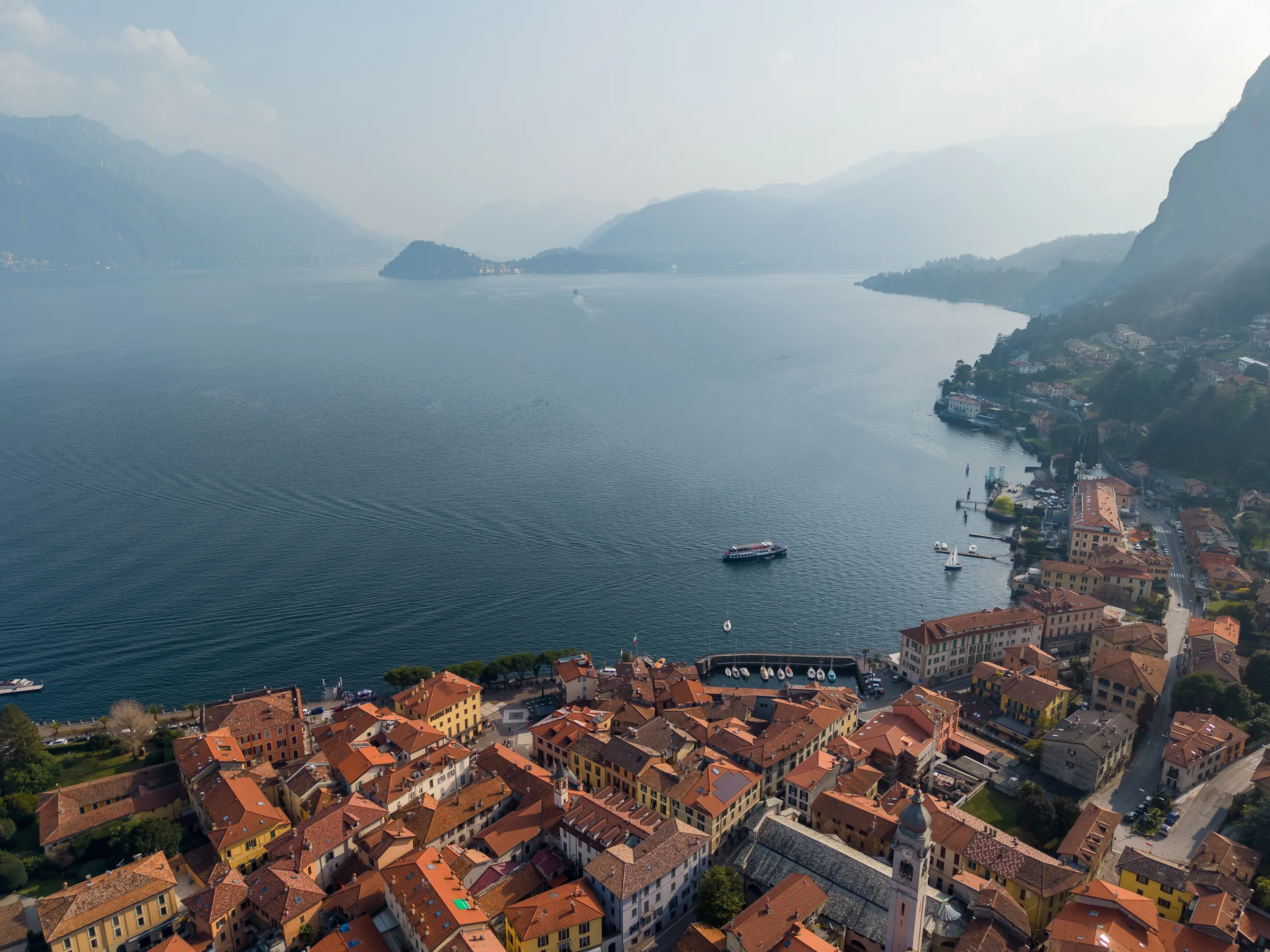 Aerial view over the lake in sunlight — Lake Como, Italy. Photography by Yunes Calore.