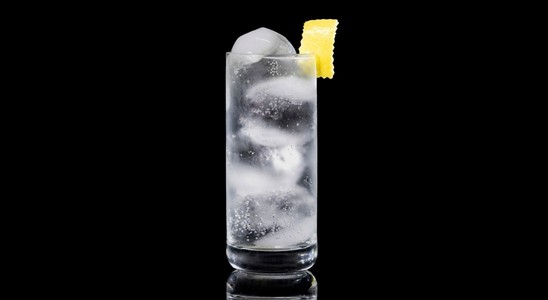 A closeup of a Vodka Tonic drink against a dark background.