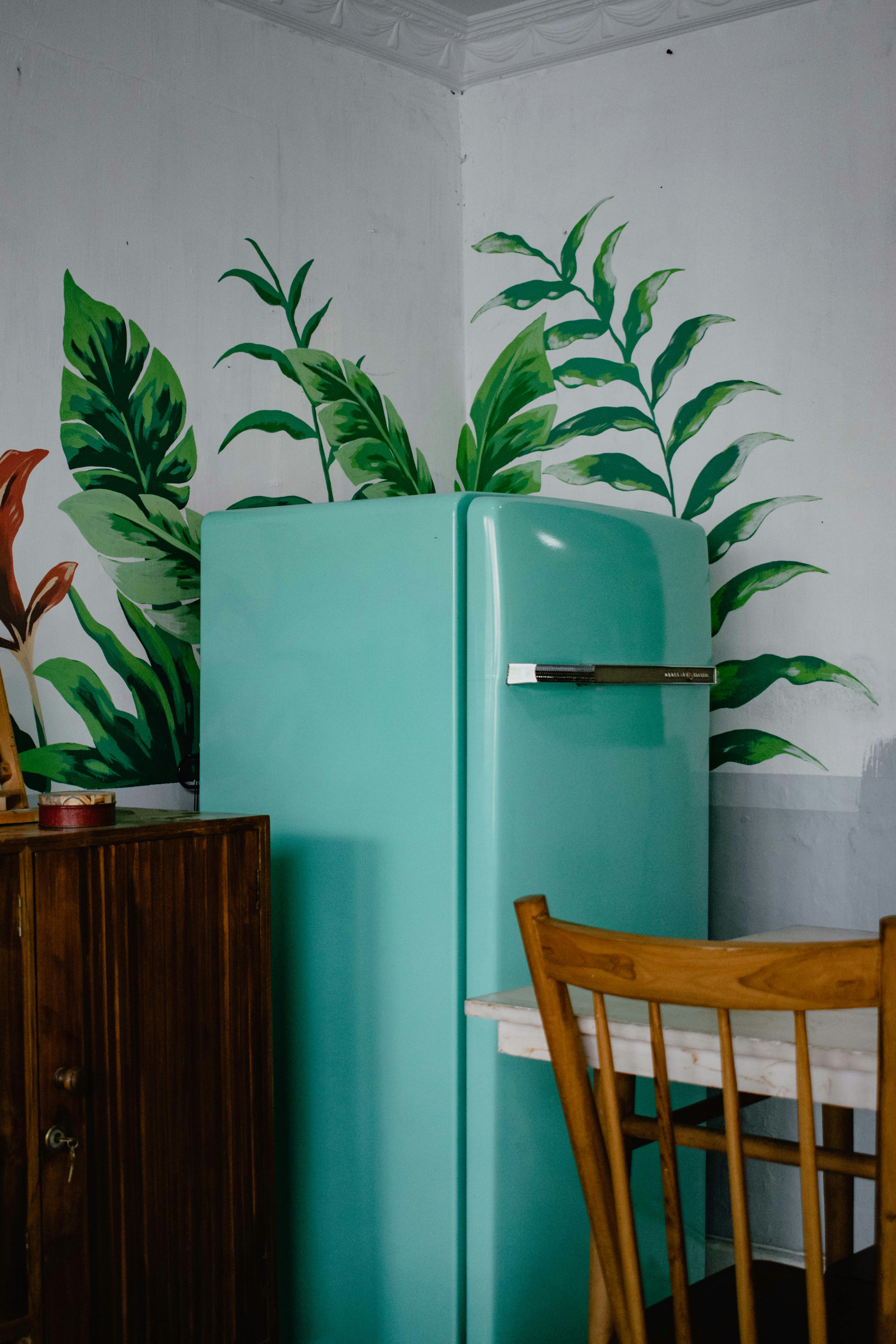 A vibrant blue fridge stands against the wall