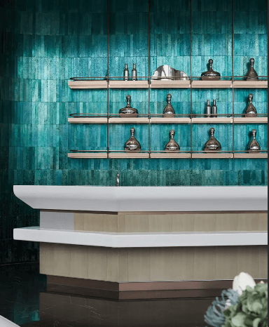 A modern bar with a vibrant electroplated green stone wall, complemented by sleek metallic shelves and elegant decor.