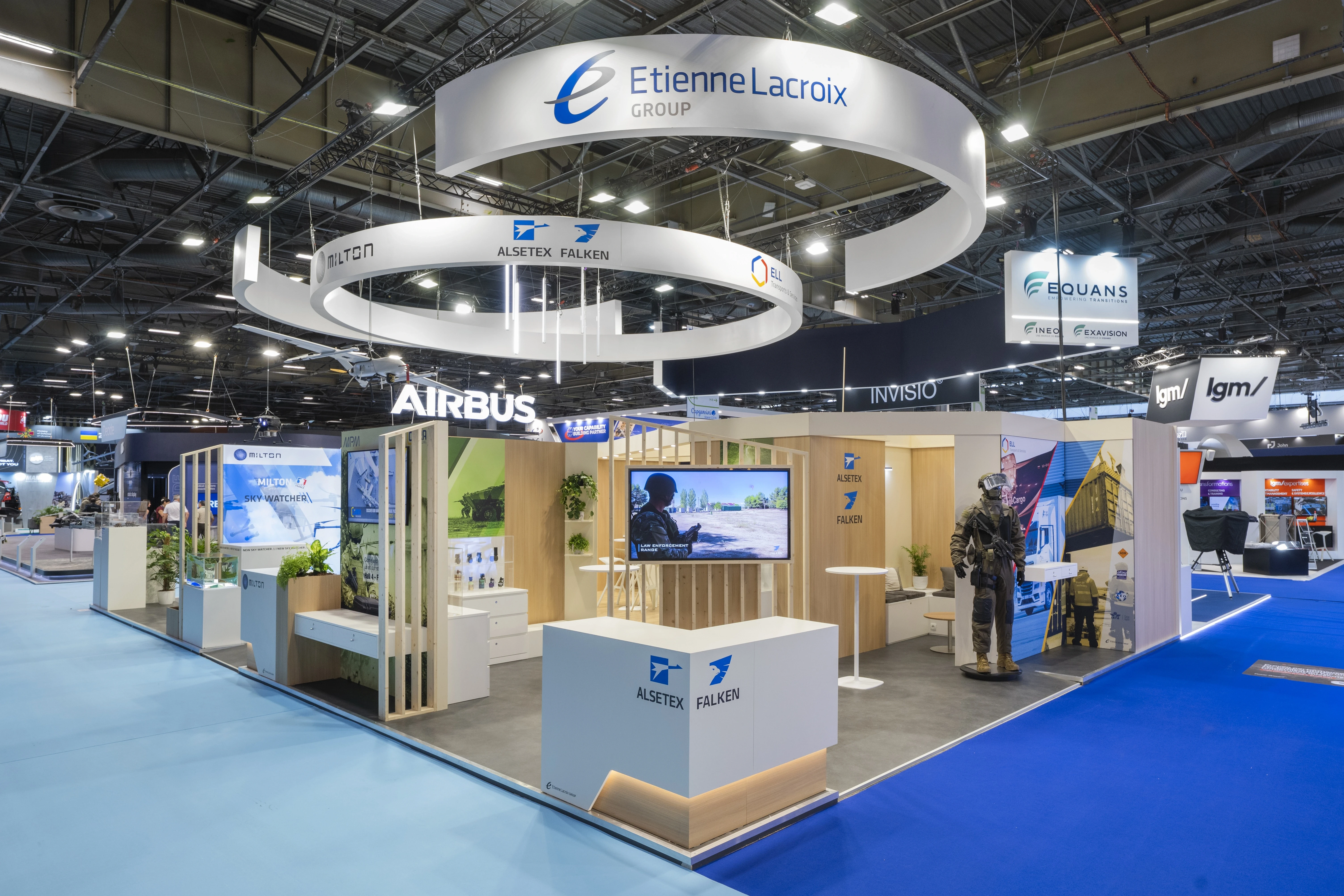 Stand Etienne Lacroix Group défense conçu par EXPACE à Eurosatory 2026 — double anneau suspendu LACROIX, Alsetex et Milton, vitrines produits et visuels d'autoprotection véhicule