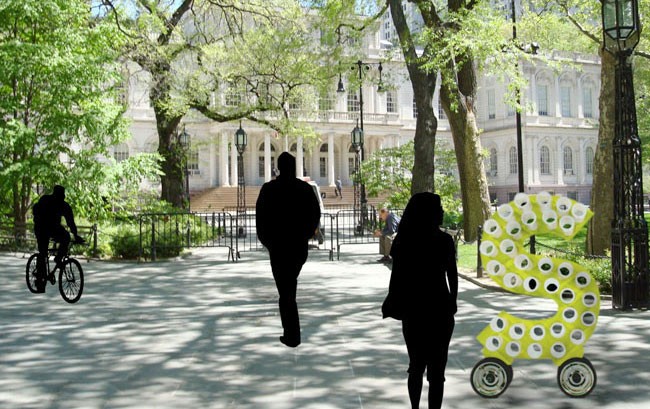 Two silhouetted figures walk away from the camera on a paved path lined with trees. A large yellow sculpture shaped like the number “5” stands to the right. A person on a bicycle is visible on the left side of the path. In the background, a large white building with columns and arched windows is visible.