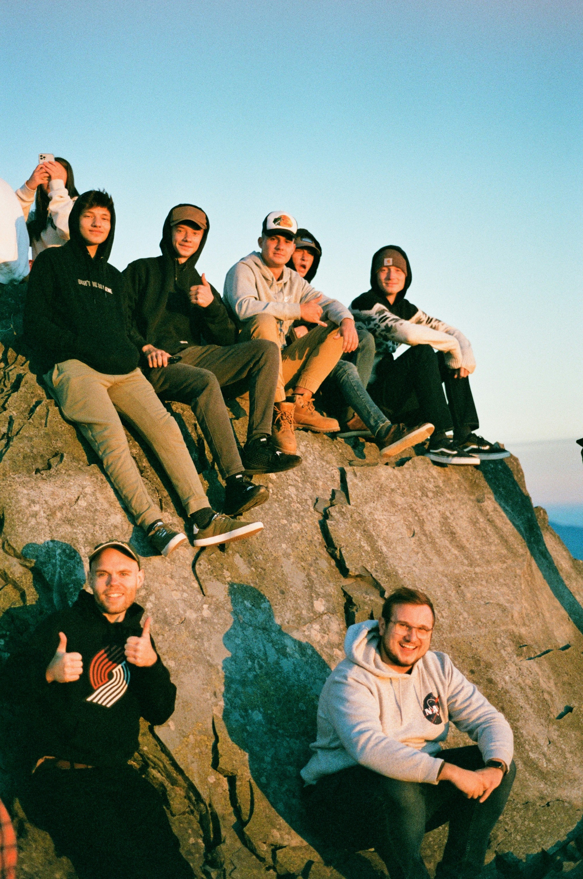 a group of people sitting on top of a rock