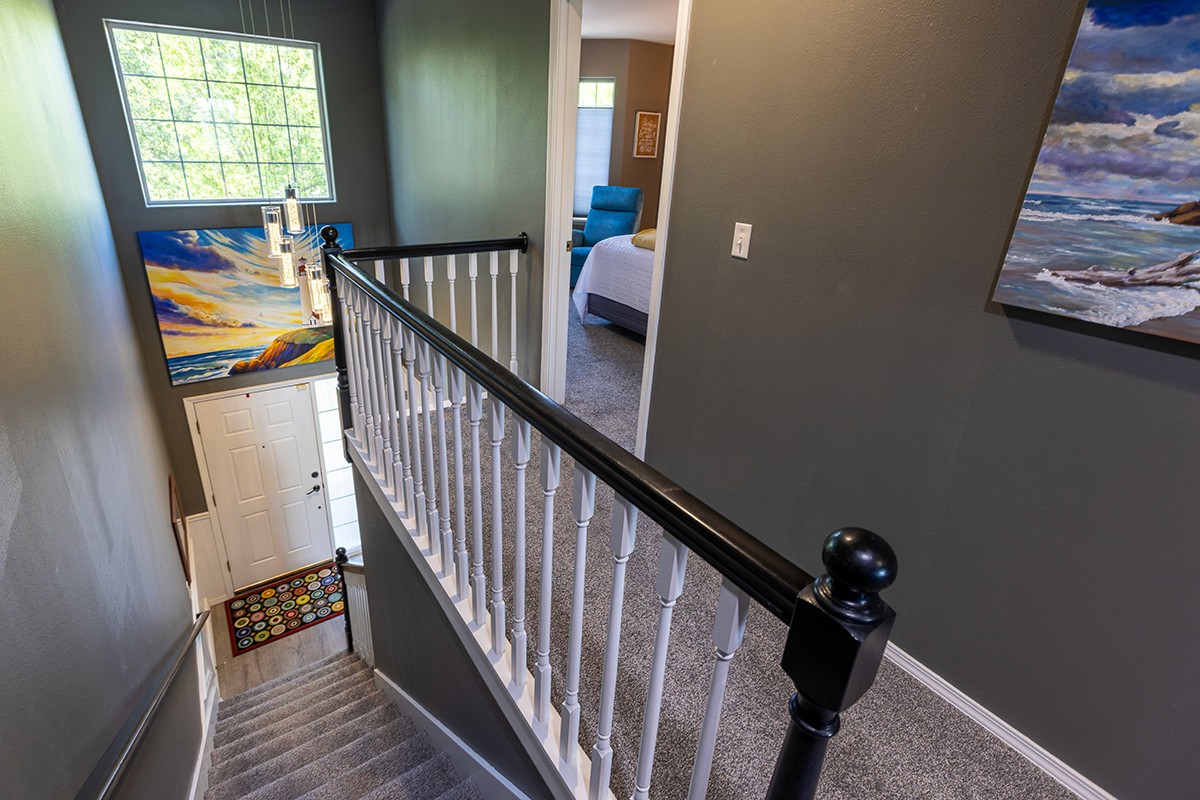 Dynamically framed, deep perspective view of a modern stairwell in a luxury Oregon property, highlighting geometric lines.