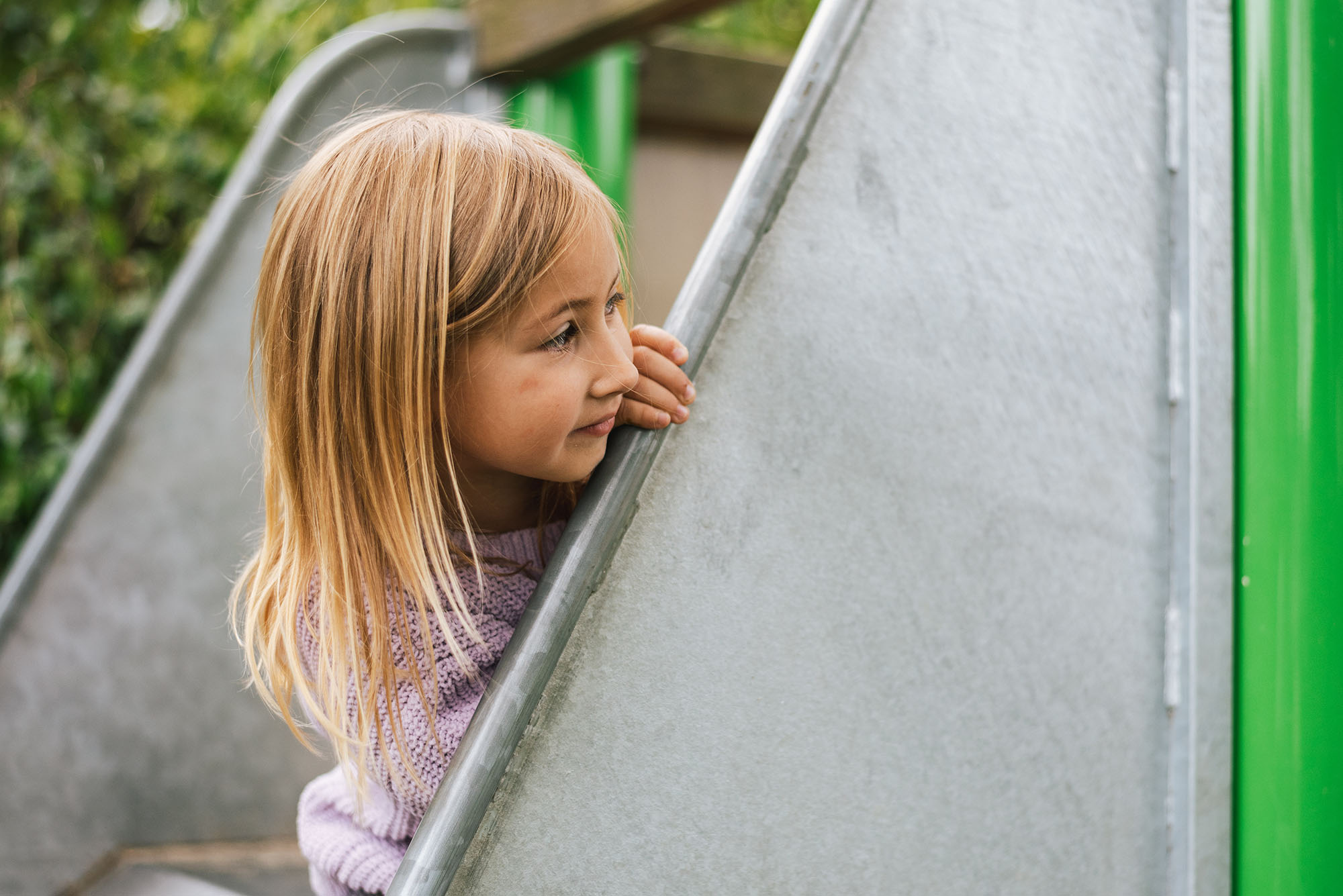 Lebendiges Kindergarten-Action-Portrait Gevelsberg: Fröhliches Mädchen lachend und begraben in bunten Plastikbällen eines Bällebads, authentischer Spiel-Moment voller Energie bei PK photography 4 Kids NRW.