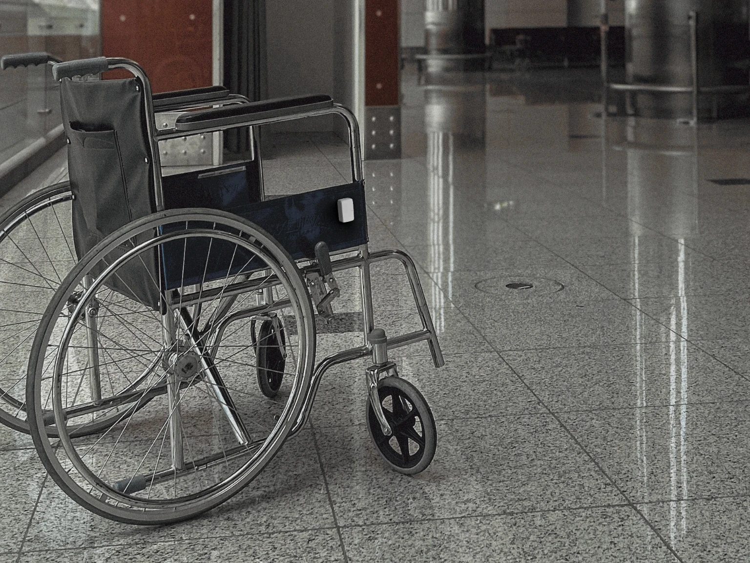 Velavu W1 tracker attached to a wheelchair in an airport
