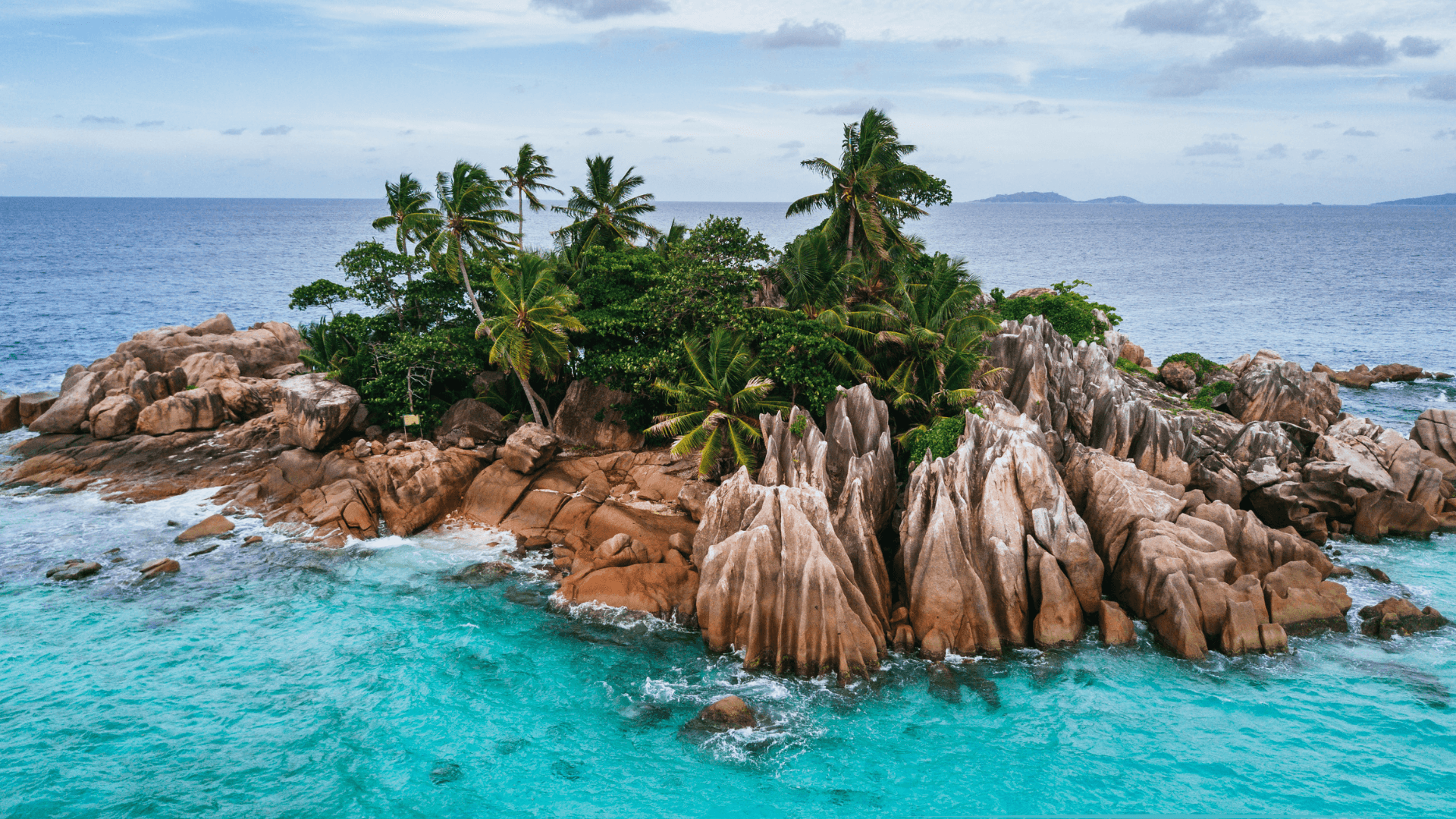 Îlot tropical aux rochers granitiques entouré d’eau turquoise, symbole d’évasion et de reset mental