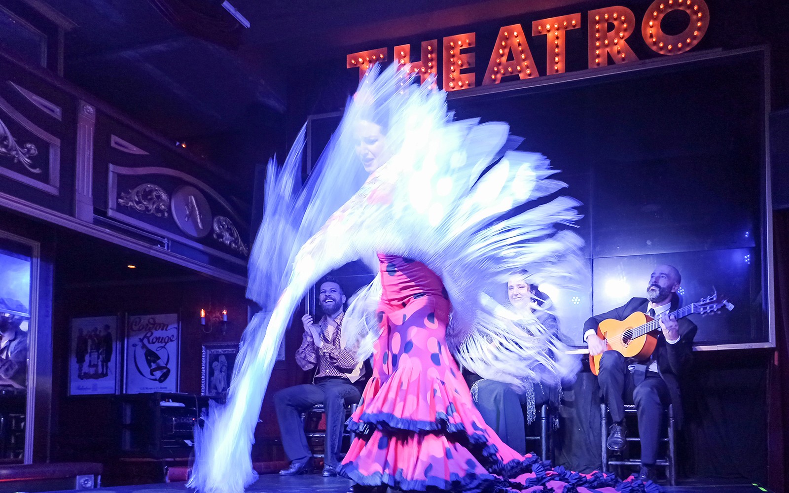 Flamenco dancer performing with musicians on stage at Esencia show.