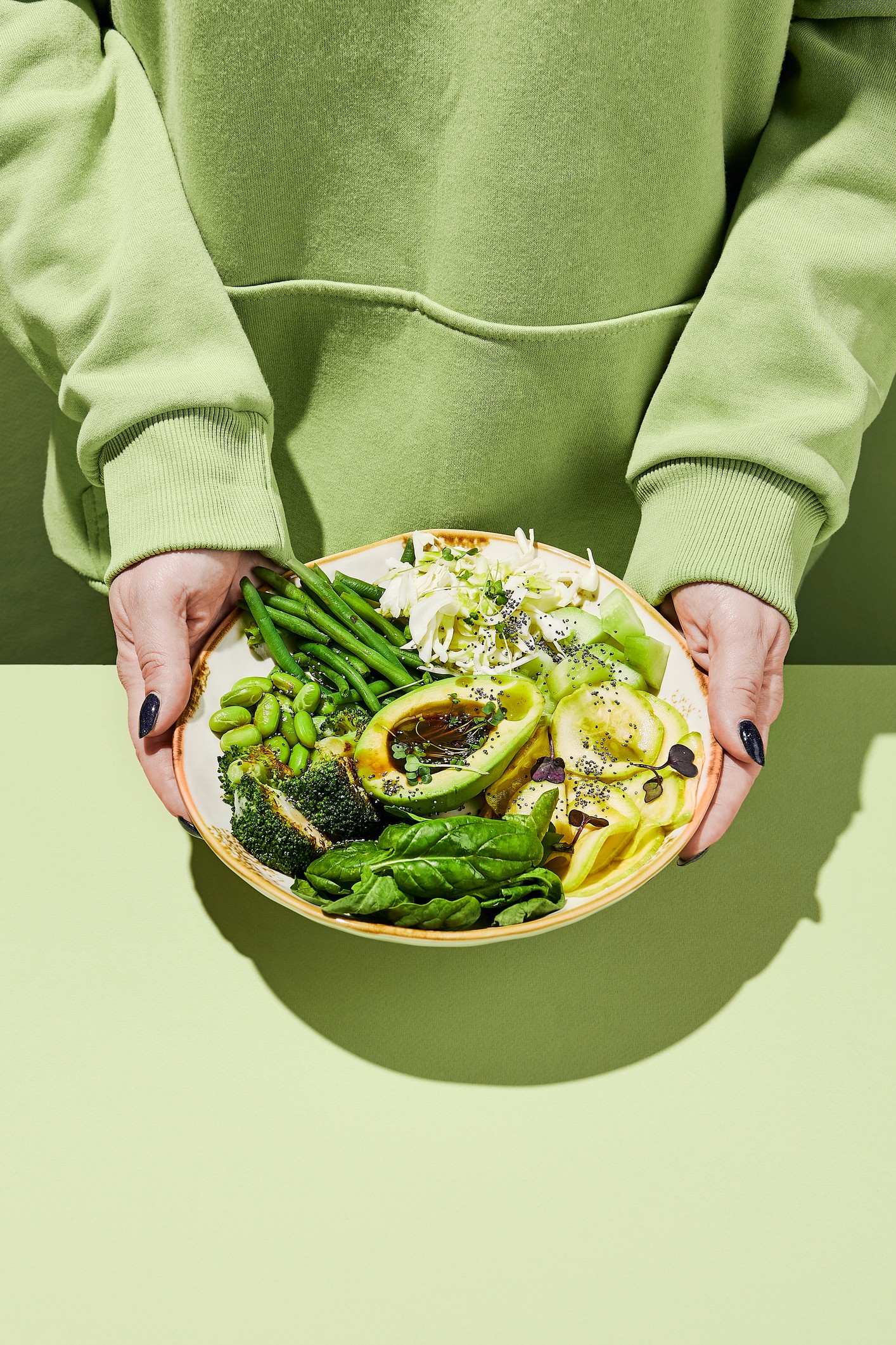 A person holding a bowl of colorful, wholesome food, illustrating that eating after diverticulitis moves through temporary phases before most foods return.