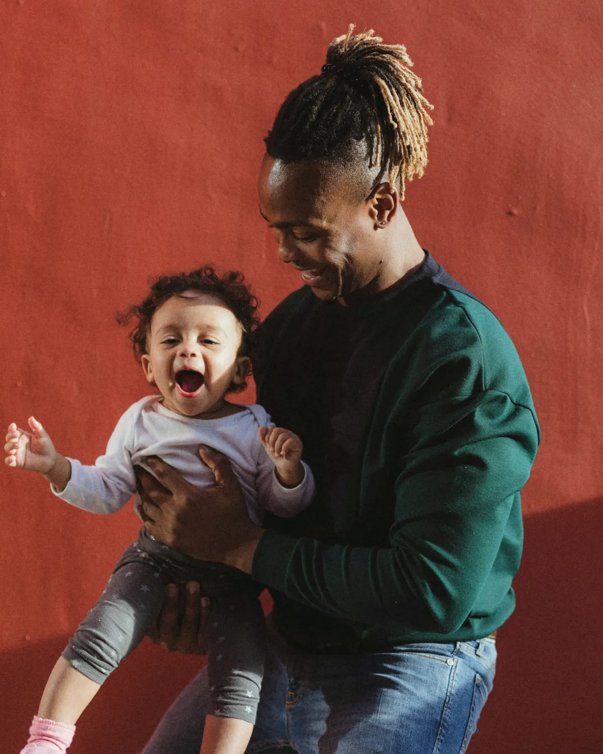 smiling dad carrying child and playing