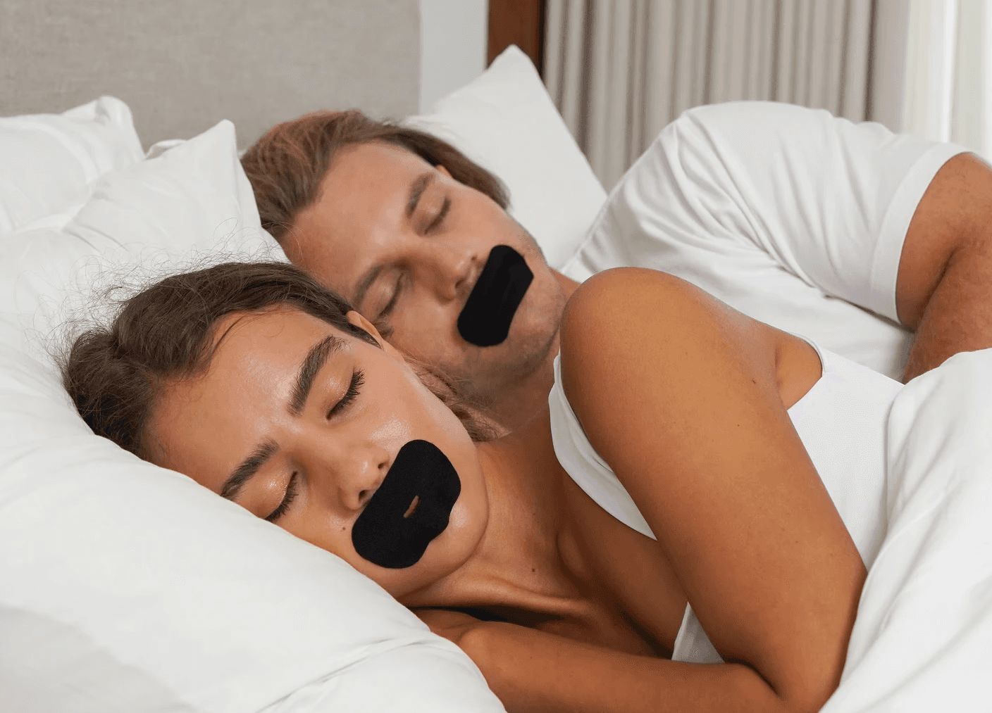 A couple sleeping with SleepSeal premium mouth tape allowing them to sleep deeper