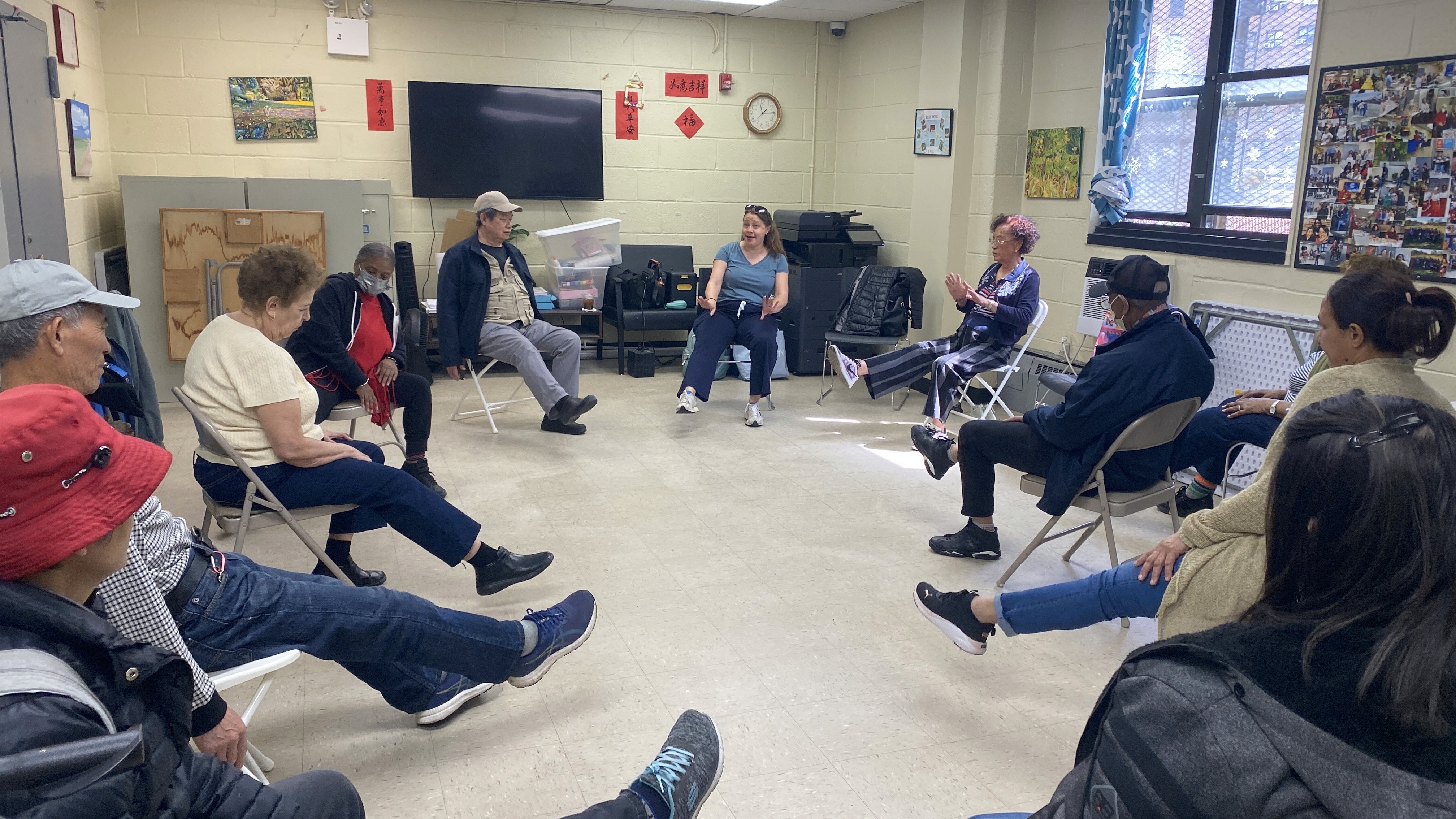 Seniors sit in a circle and listen to an instructor.