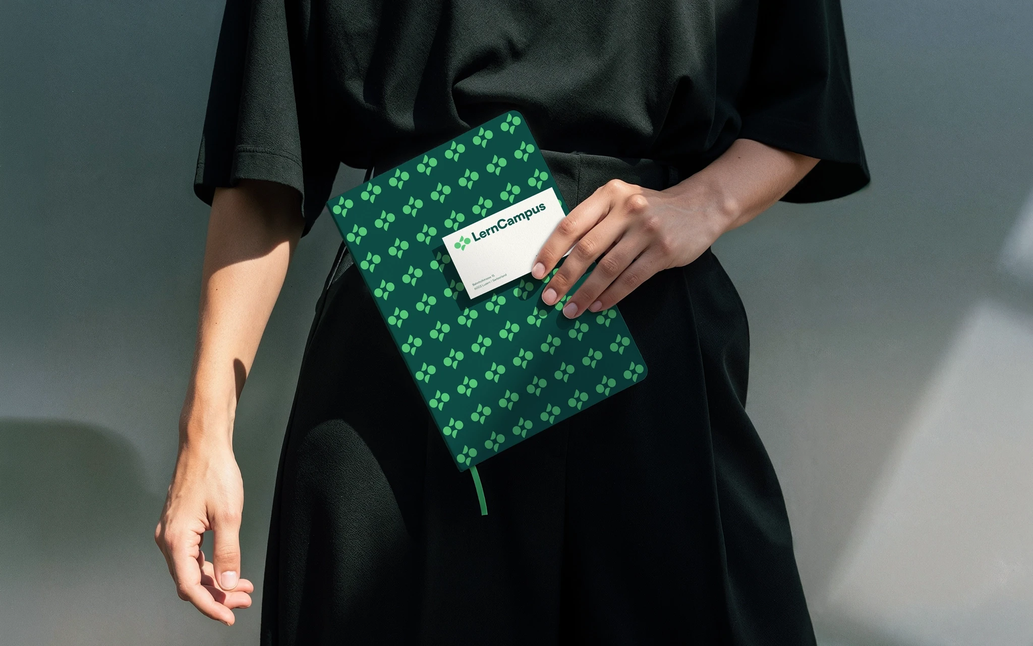 Pessoa que segura um caderno verde da LernCampus com capa estampada