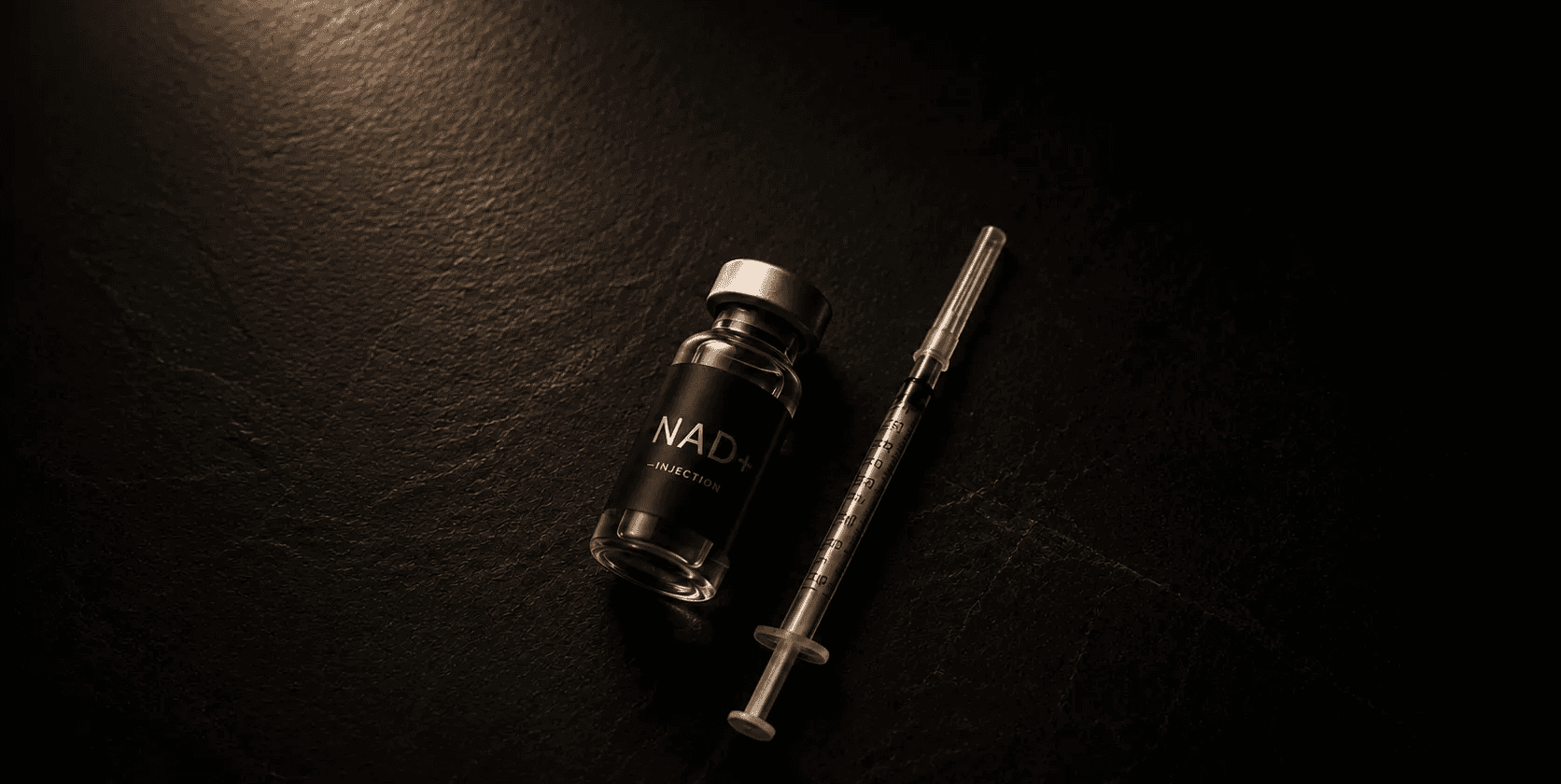 Image of NAD+ vial next to a syringe.