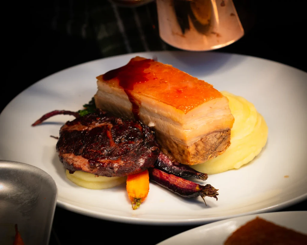 Rare breed pork belly with smoked pork cheek, pomme purée and baby carrots