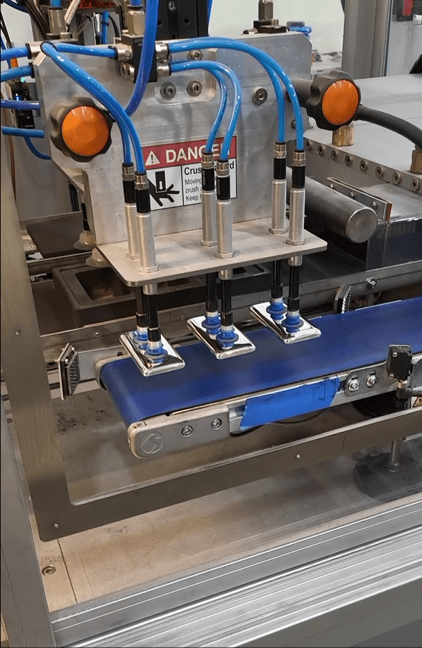 Industrial minting machine producing custom, IRA-eligible gold and silver bullion bars.