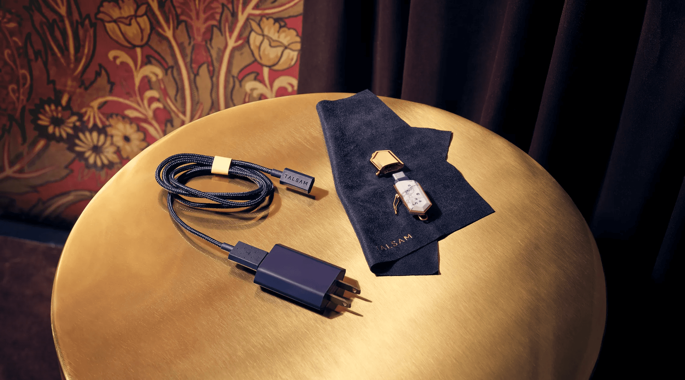 Talsam smart jewelry charging cable and accessories arranged on a gold table