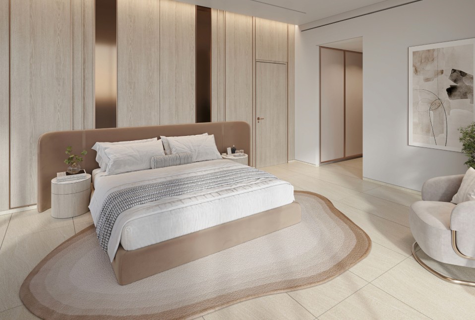 A serene bedroom featuring a large window with a picturesque view of the water, designed by The Caden by Prescott.
