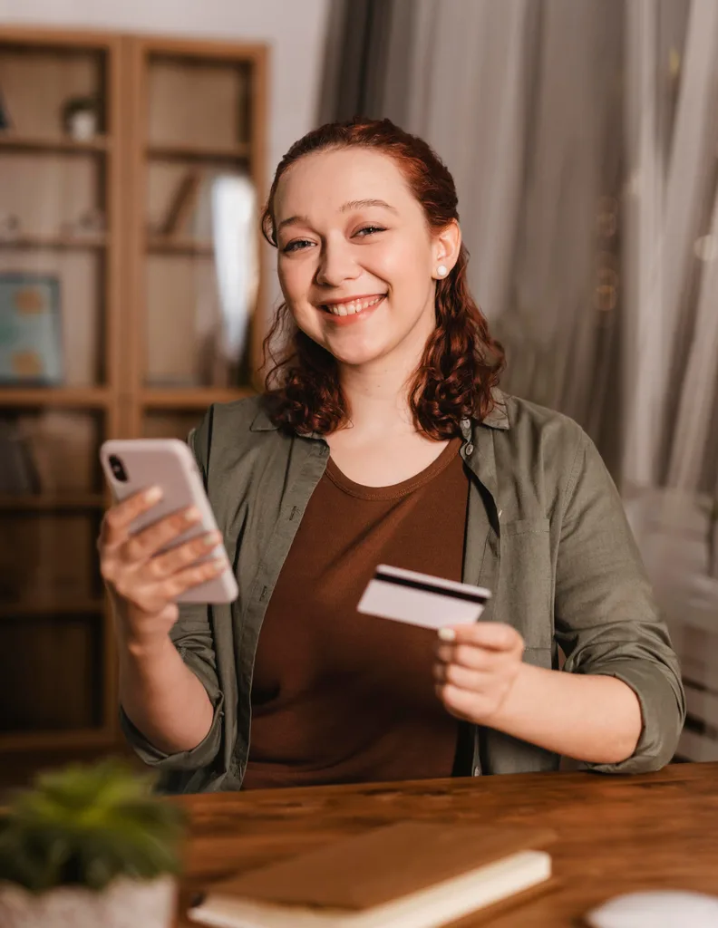 Smiling woman holding a phone and a card