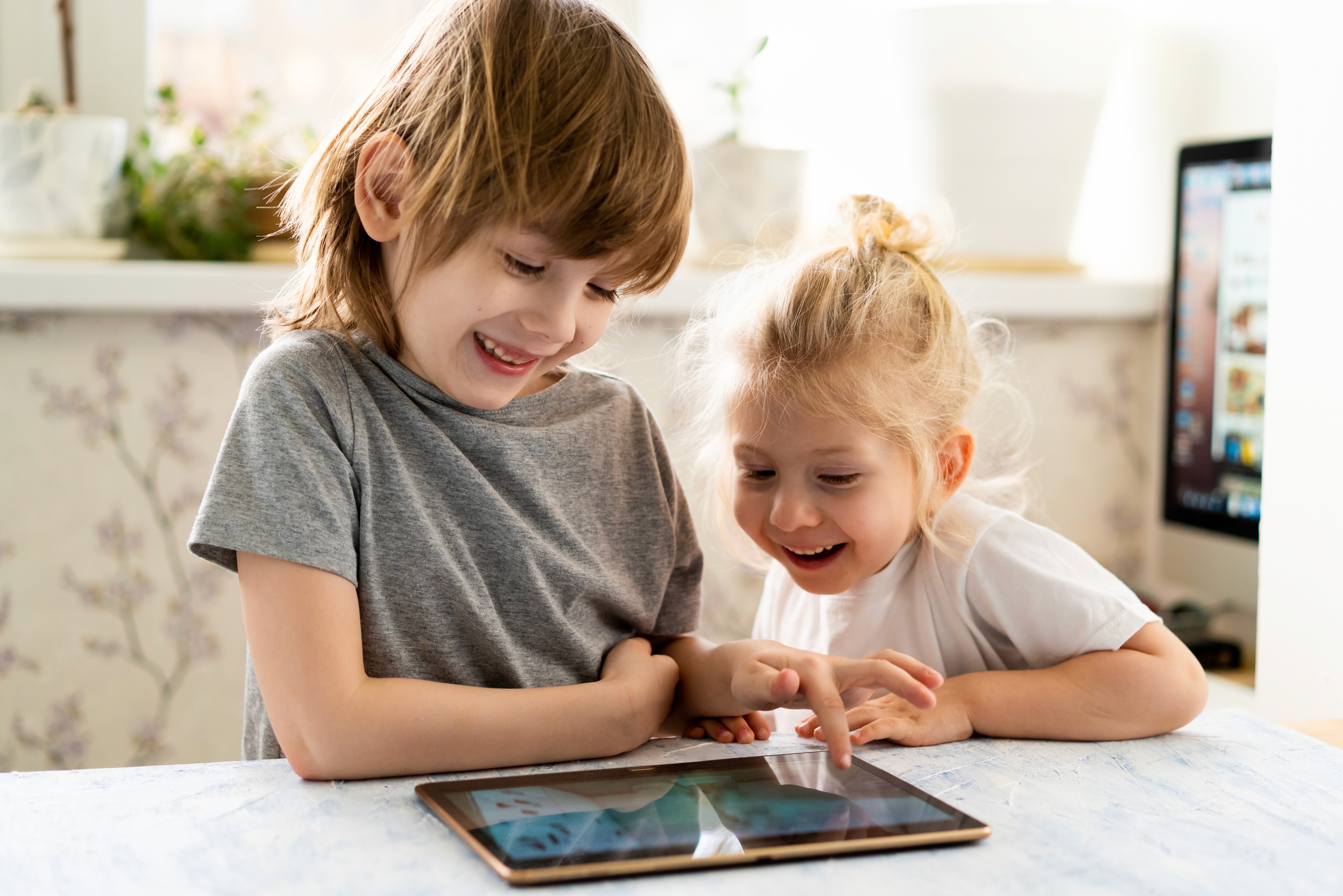 Kinder lernen spielerisch am Tablet und sind happy