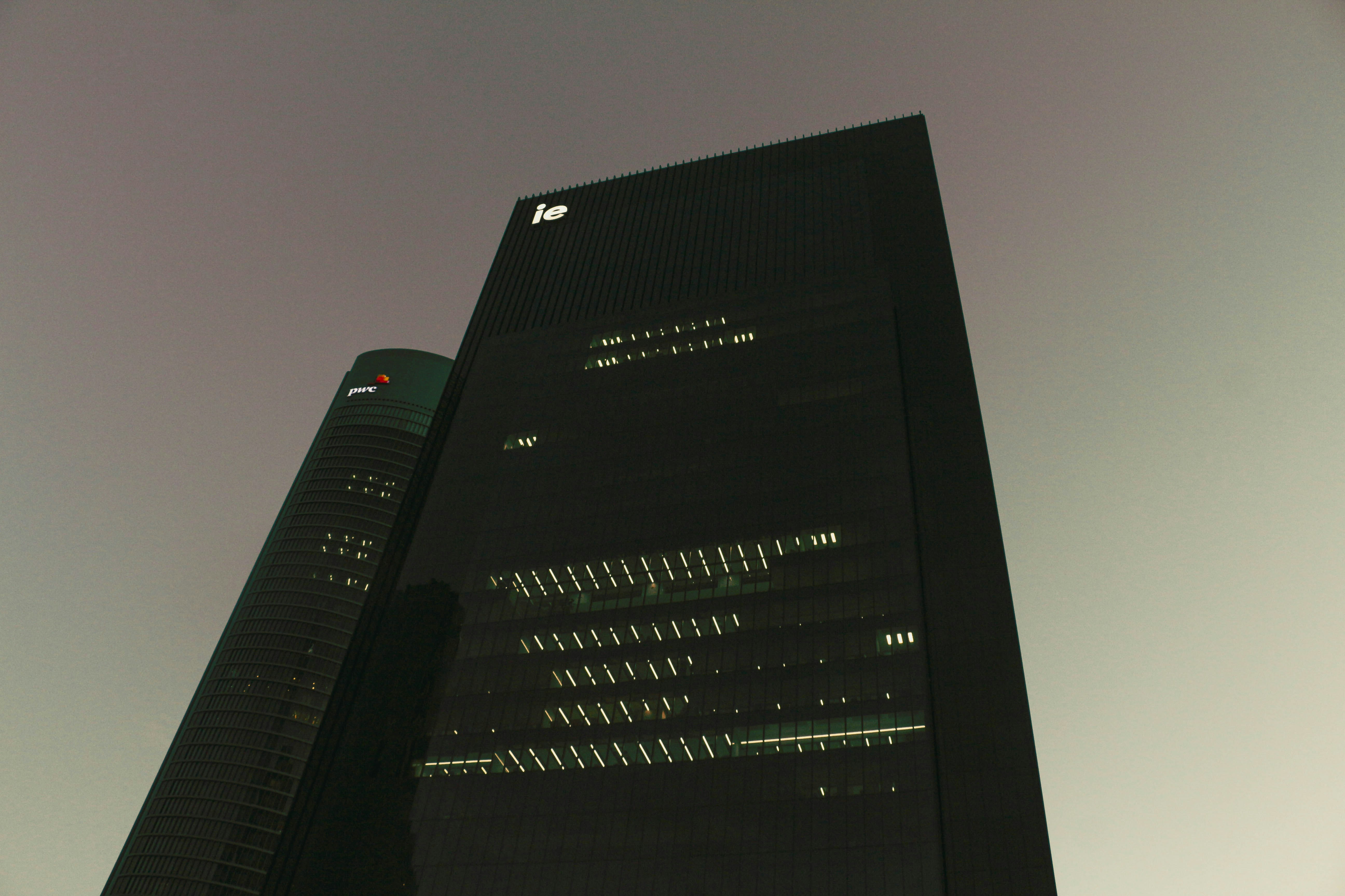 Two dark skyscrapers against a hazy sky.