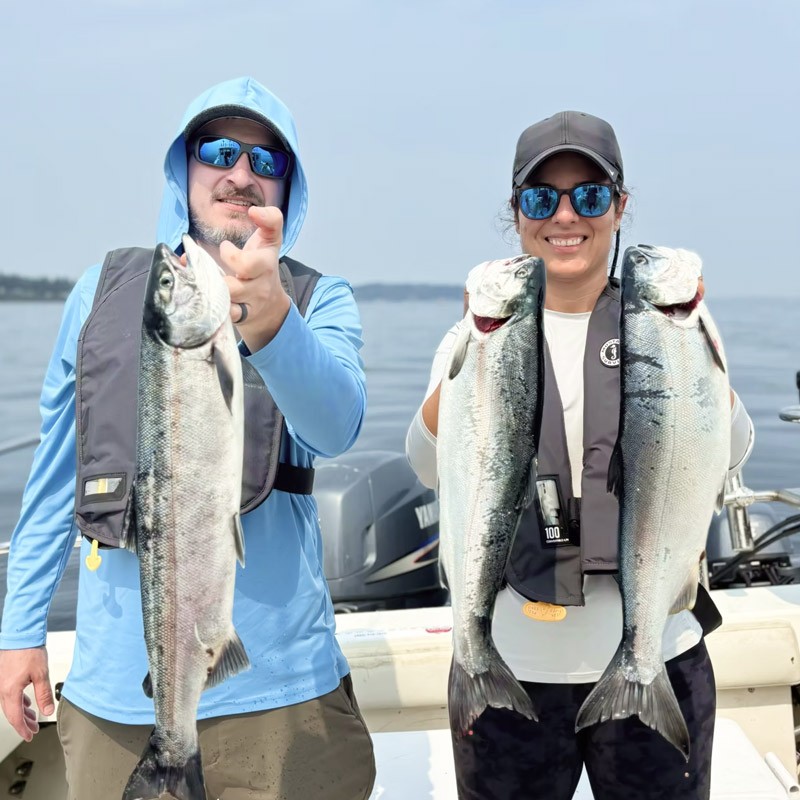 Couple holding freshly caught salmon