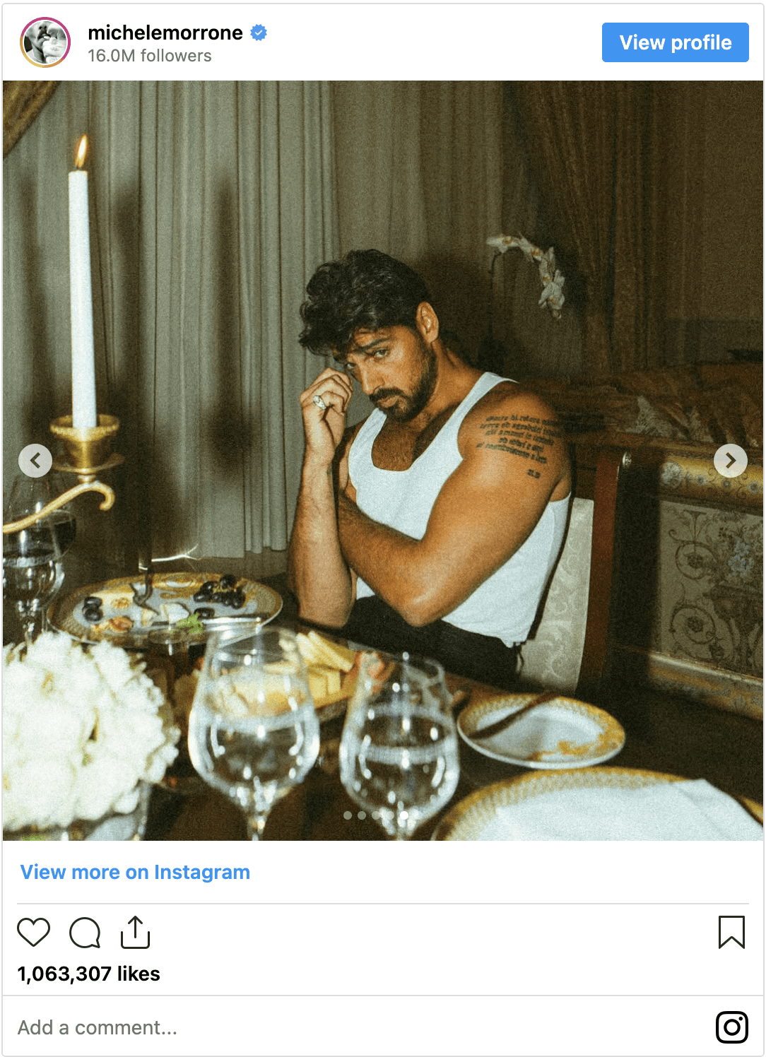 Black-and-white party photo of a smiling man in a check blazer among a crowd.