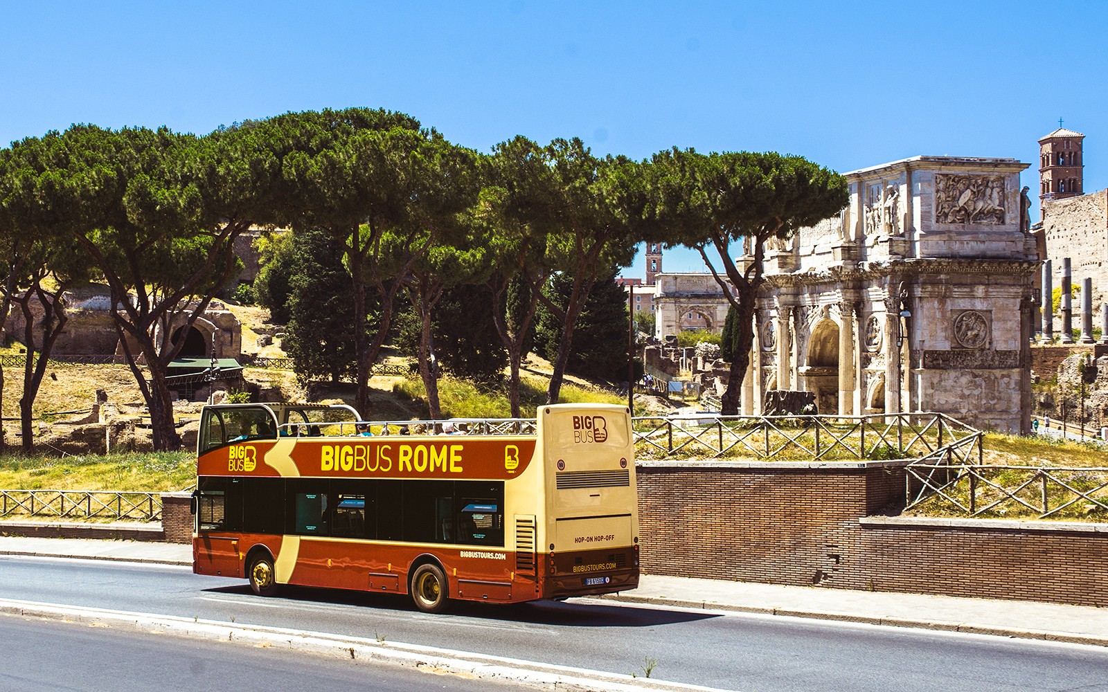 Dubbeldeksbus met open dak die langs het Colosseum in Rome, Italië rijdt, als onderdeel van Big Bus Tours Rome.