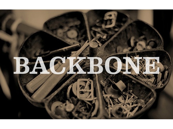 A black and white close-up image shows several small metal containers arranged on a circular surface. The containers hold various small metal objects, including what appear to be tools or hardware pieces. The containers are slightly separated from each other, and the objects within them are densely packed. The word “BACKBONE” is superimposed in bold white capital letters across the center of the image.