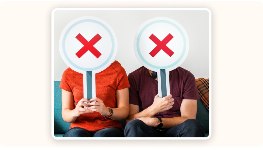 Two people holding red X signs