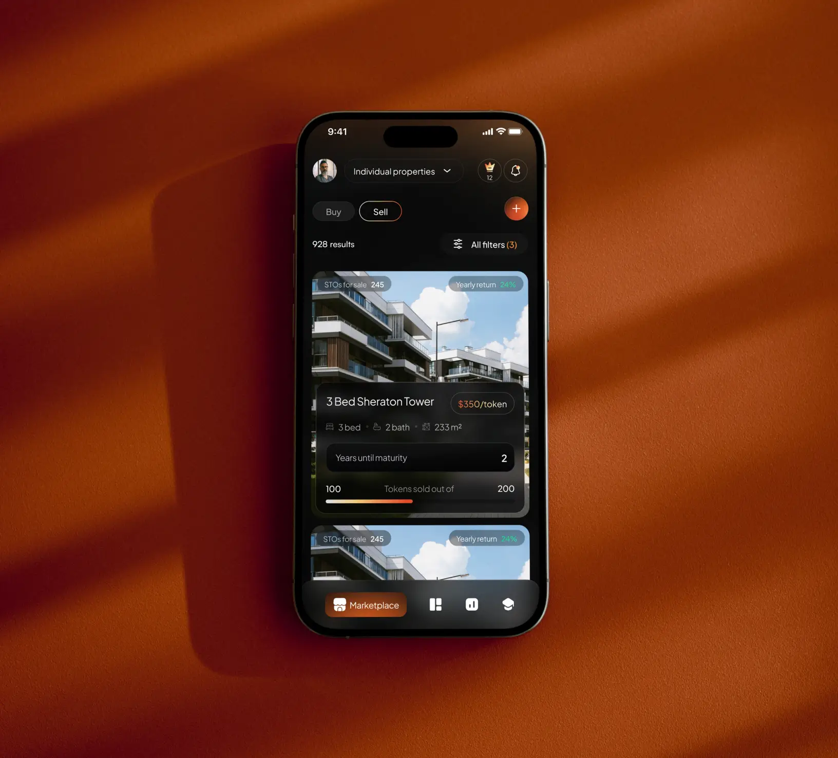 A phone on an orange table showing a website interface for a real estate project