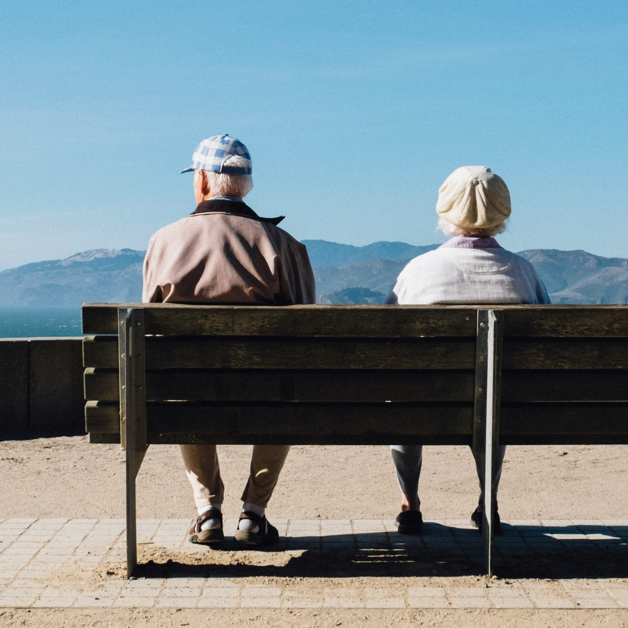 Two people sitting in front of a mountain