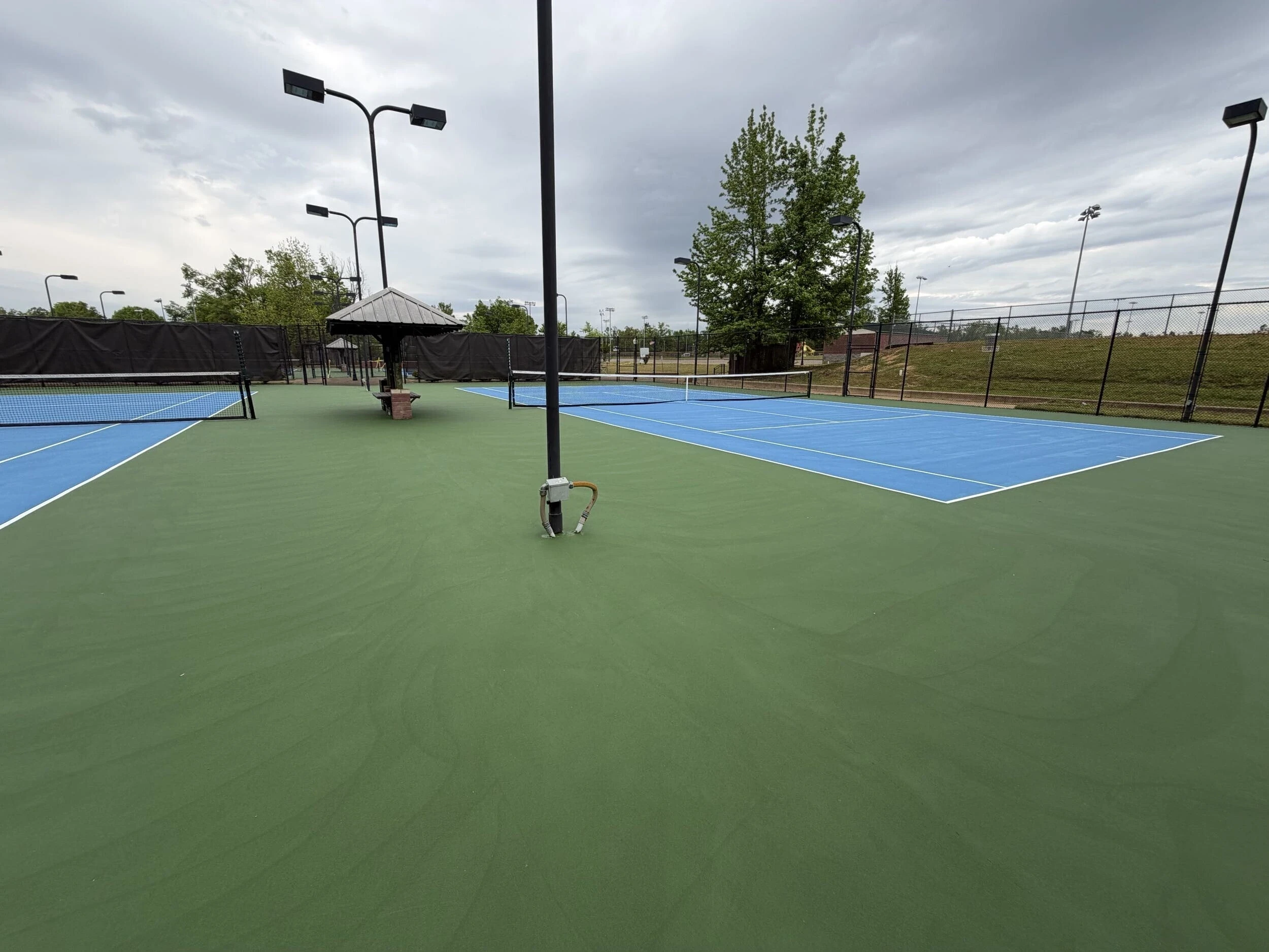 Completed tennis and pickleball court resurfacing showing fresh blue and green acrylic surfaces in Corinth, MS