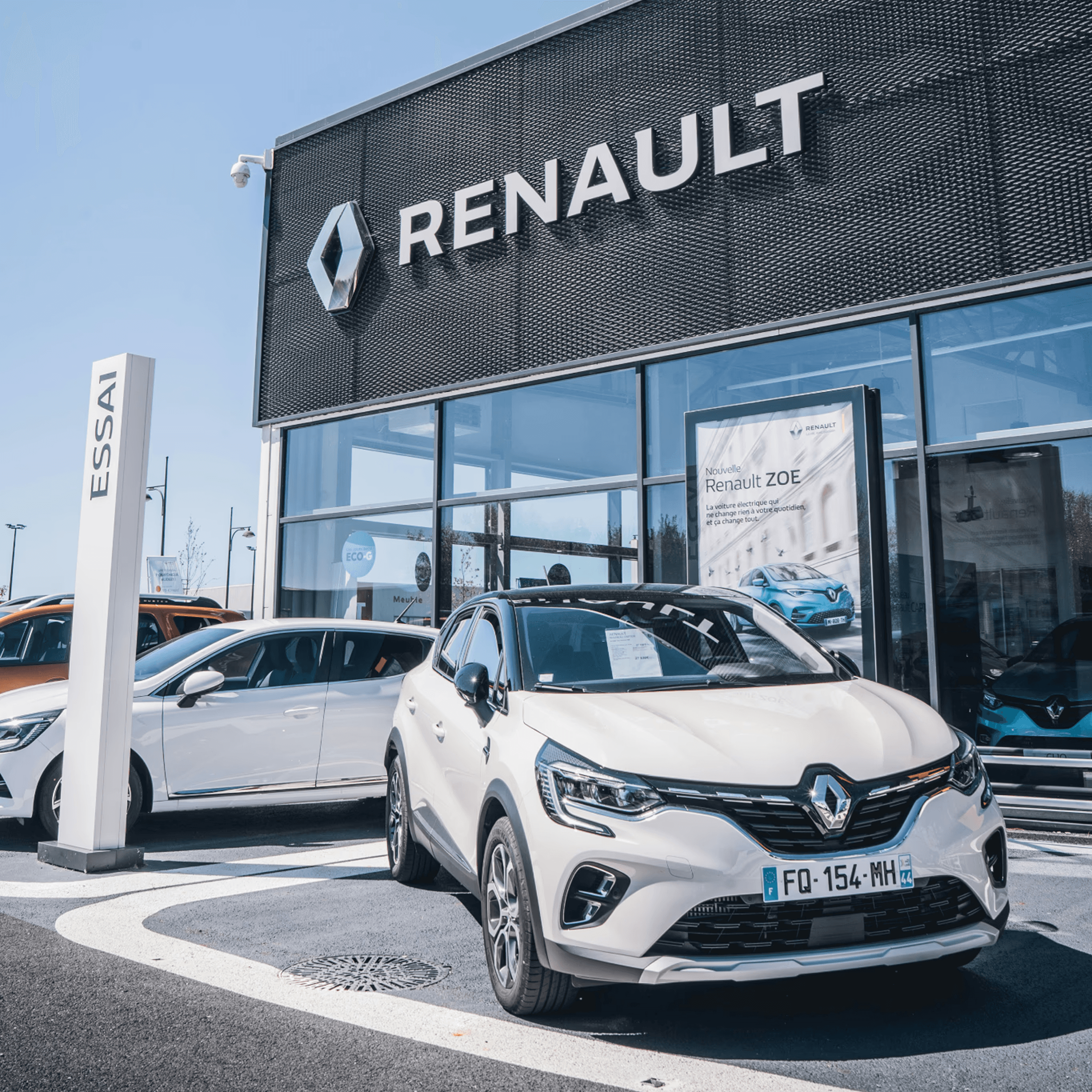 Concessionaria Renault con auto bianche in esposizione.