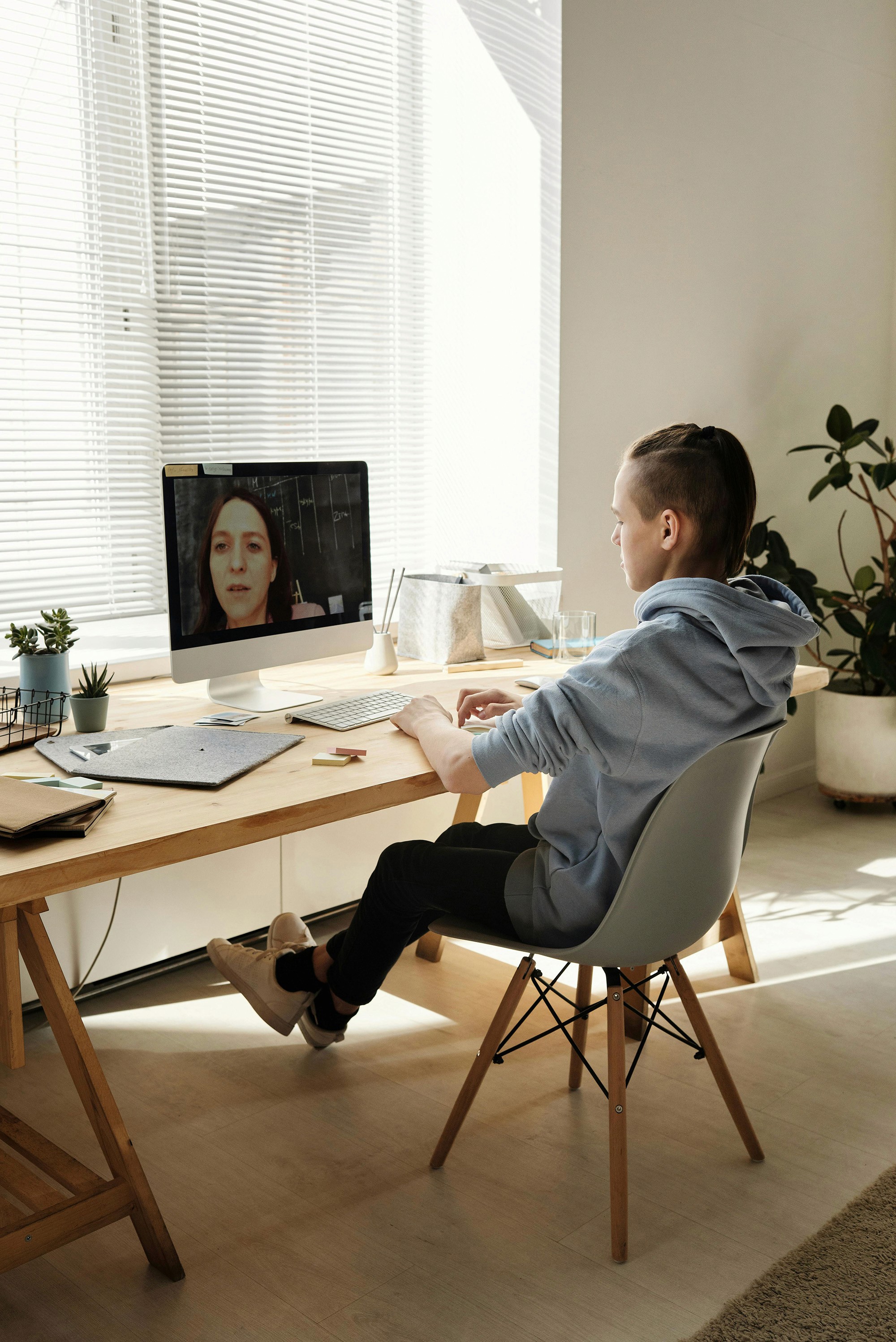 A video call with a teacher is displayed on the screen