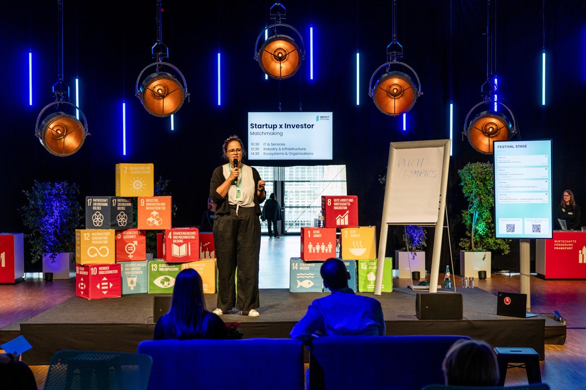 Drei Geschäftspersonen stehen an einem Konferenztisch und diskutieren intensiv