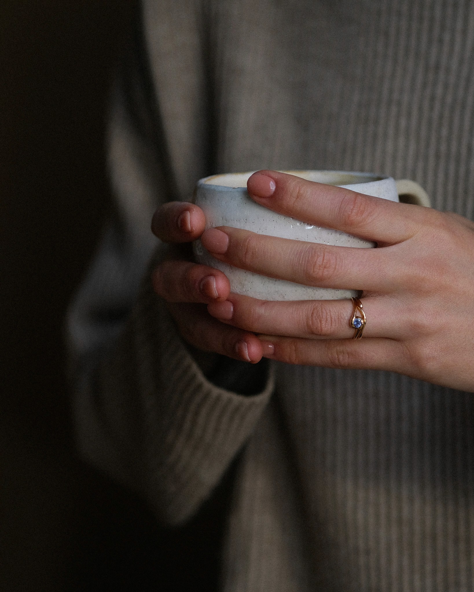Hand wearing The Yu Do holding a mug