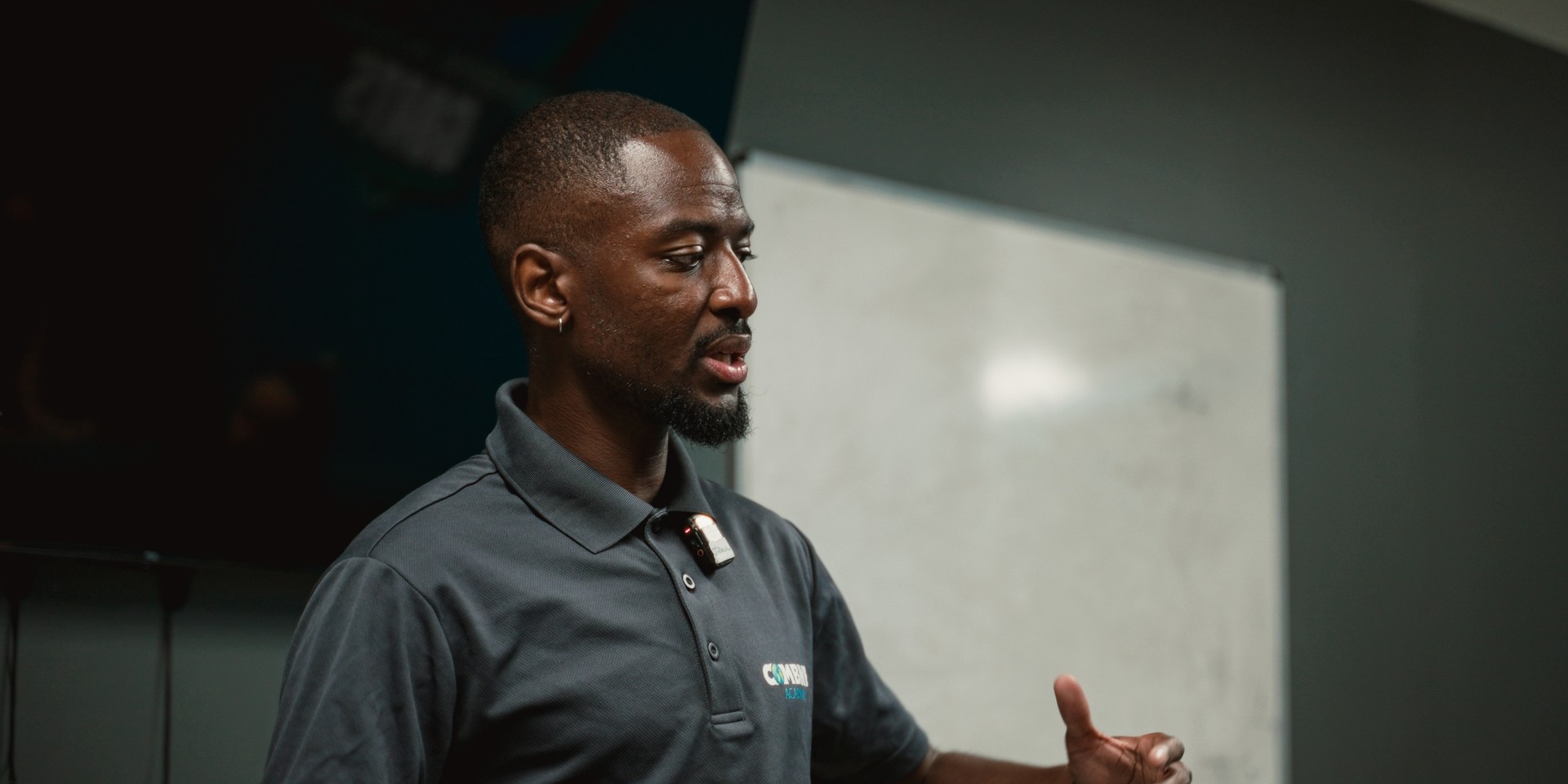Coach en briefing devant un tableau blanc à la Combine Academy.