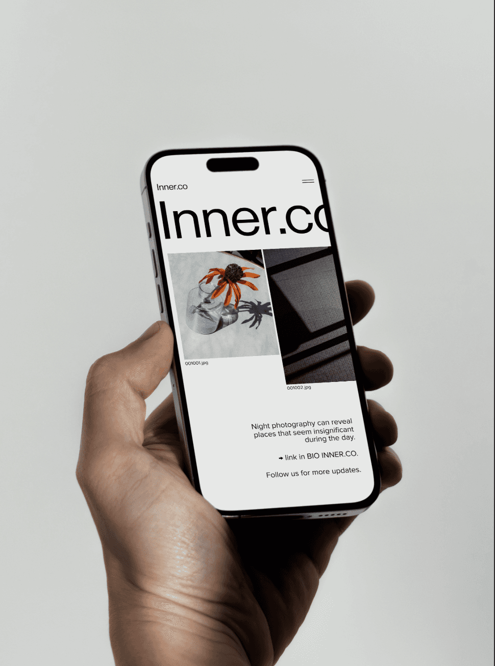 Handheld iPhone mockup showing a minimalist, photography-focused mobile web design for Blinders App