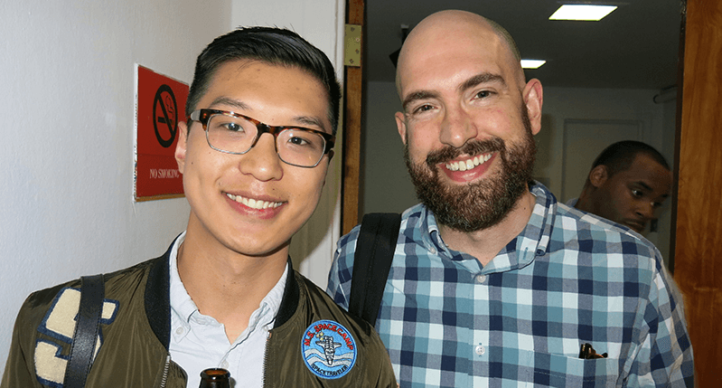 A photo of two men standing in an exhibition room.