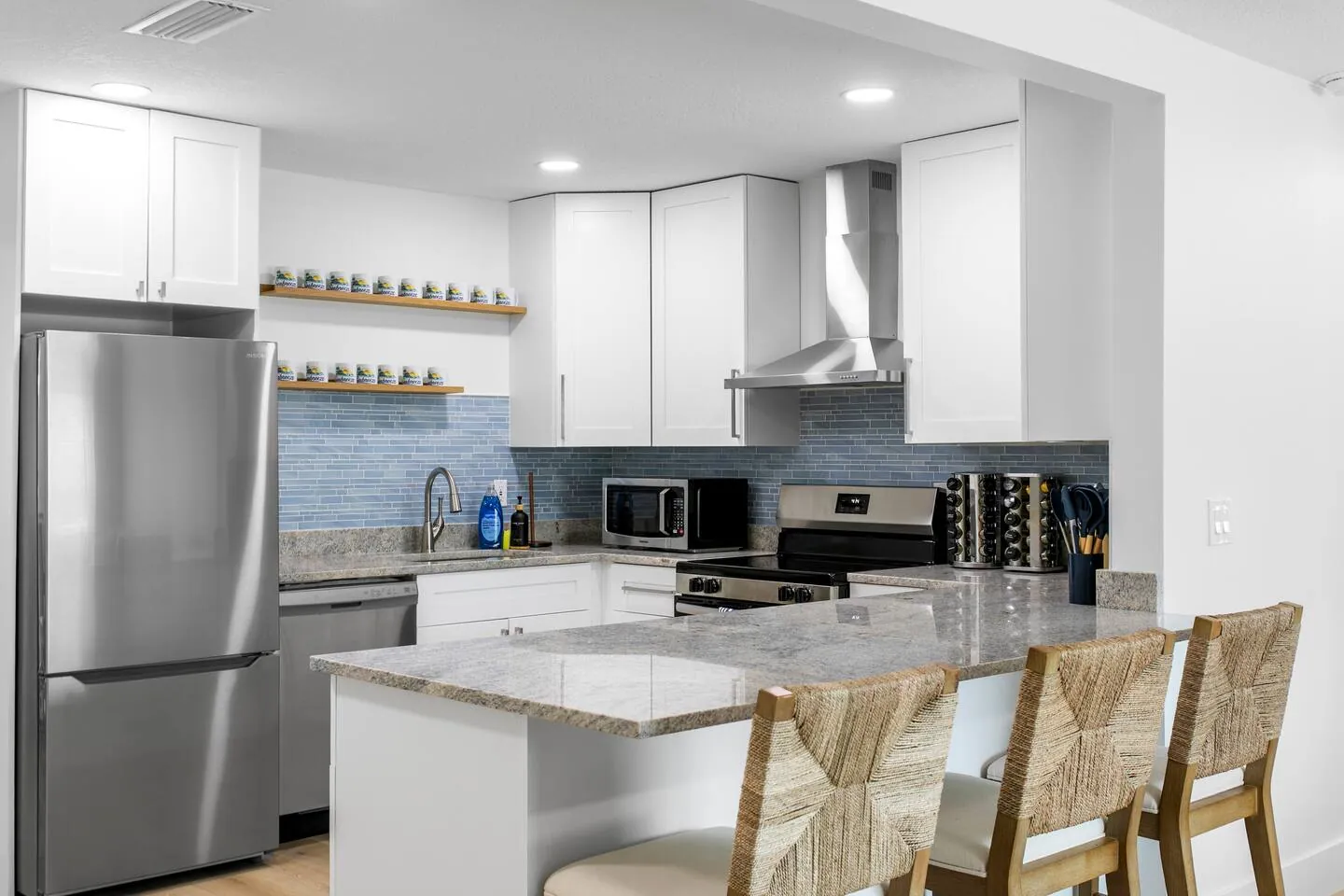 Kitchen with white cabinets and island seating at Salty House, Bradenton, Florida