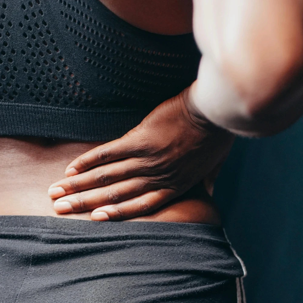 A woman holding her back up in pain