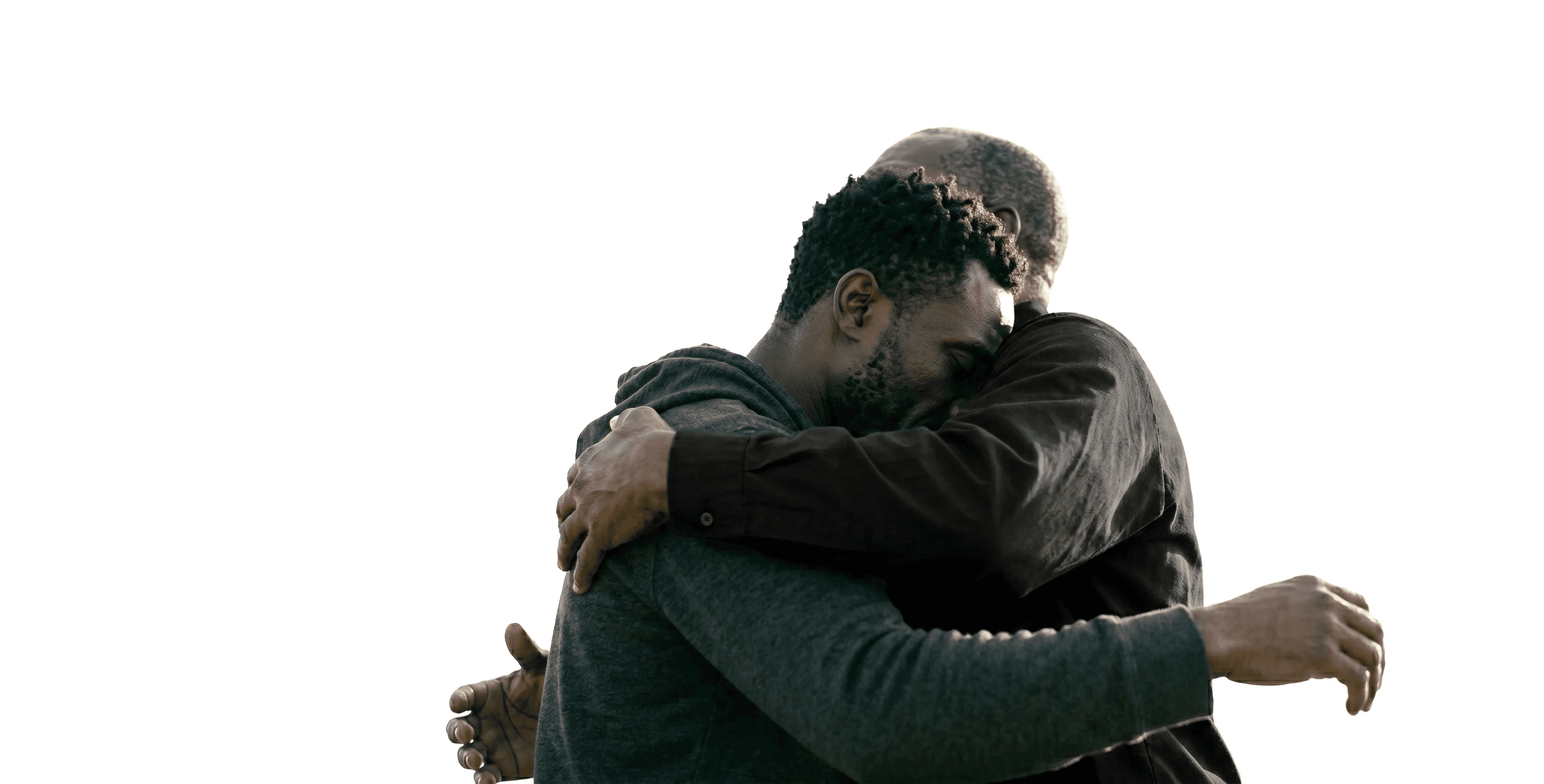 Two individuals share a heartfelt embrace against a plain white background, highlighting themes of connection, warmth, and emotional support.