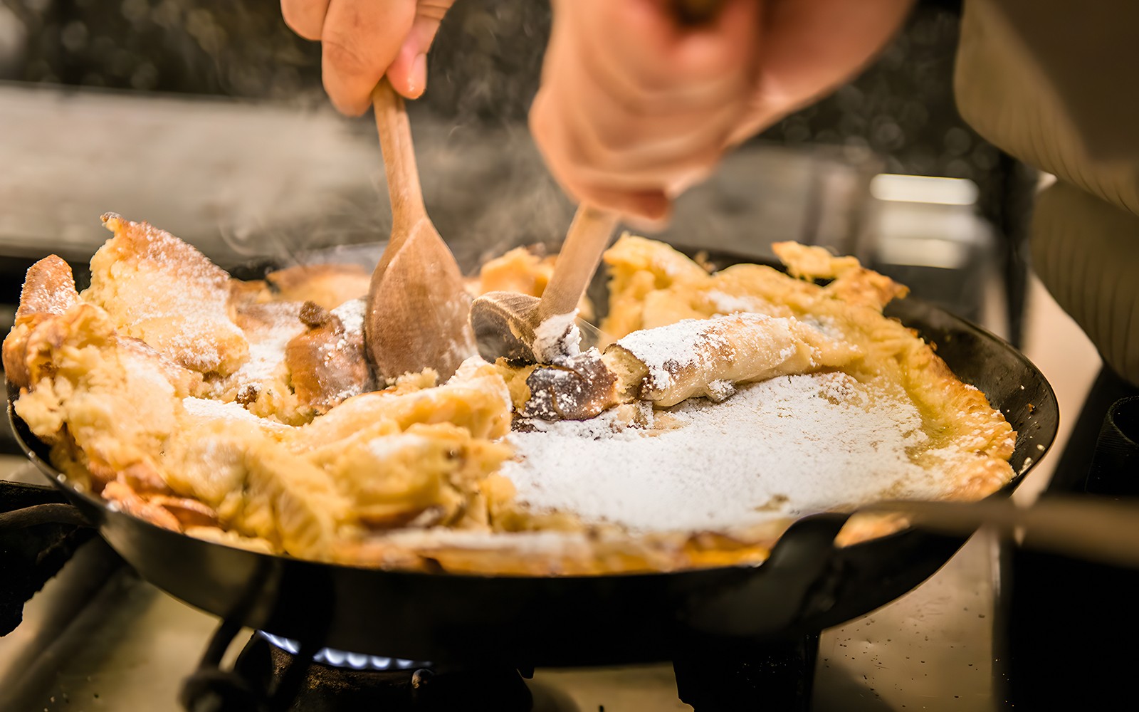 Cooking Kaiserschmarrn in a pan during a traditional Austrian cooking class.