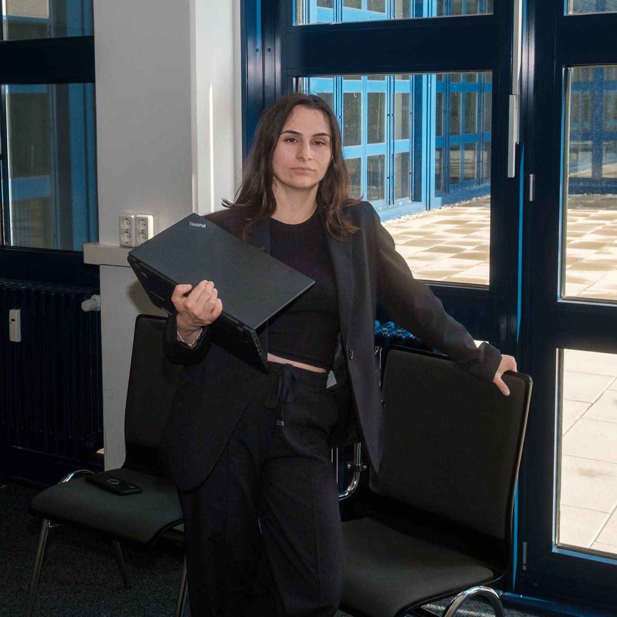 Woman standing with laptop in her hands