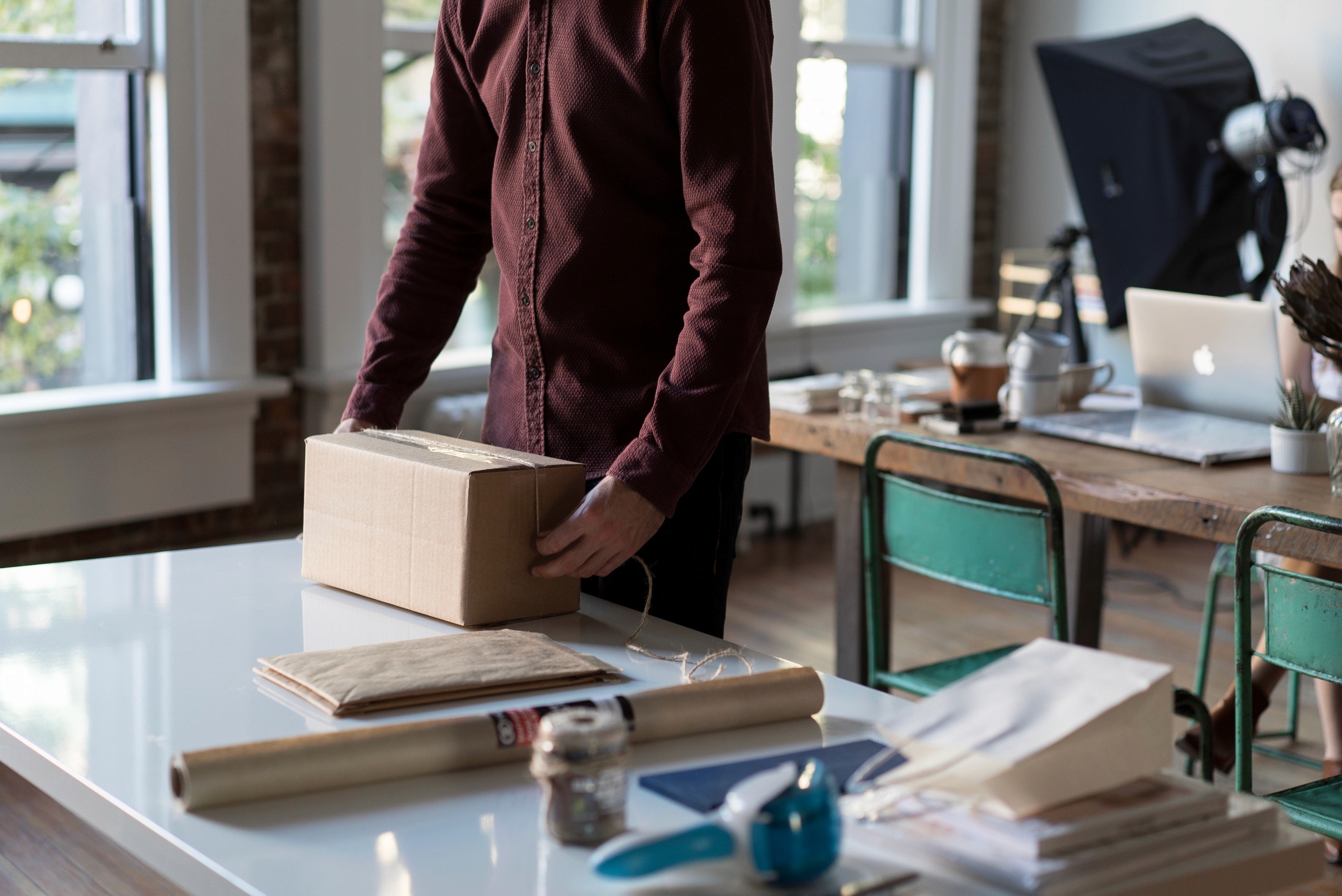 A retailer packing a parcel at a workbench