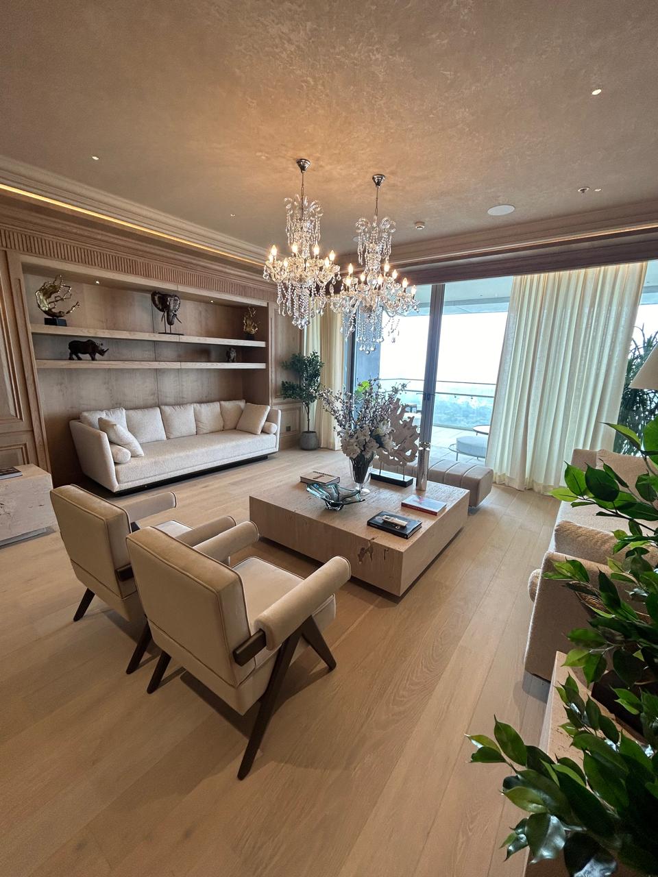 Vintage-inspired luxury living room with tufted sofas, crystal chandelier, soft neutral palette, and modern detailing in Pune.