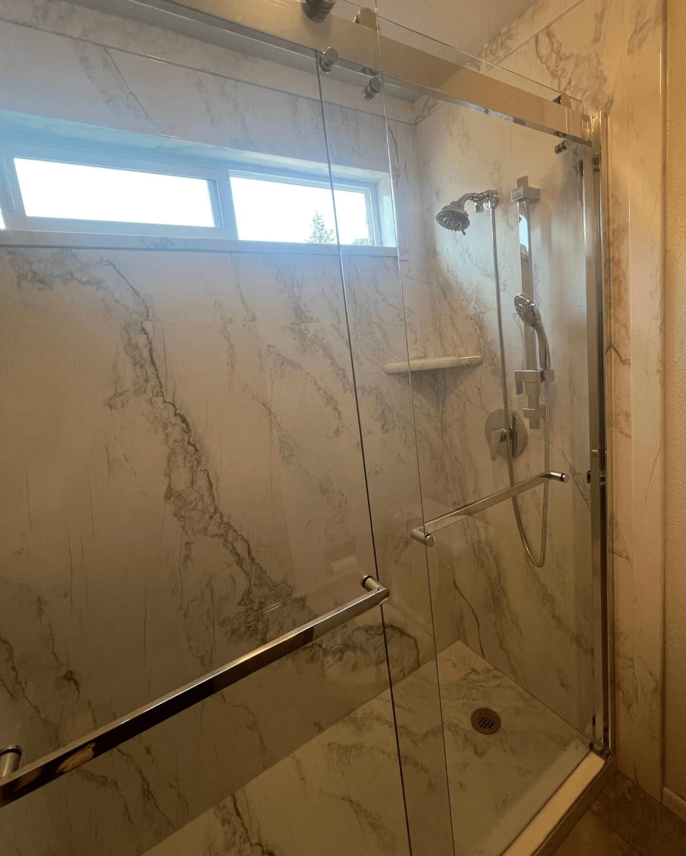 Newly remodeled shower with chrome fixtures and waterproof walls